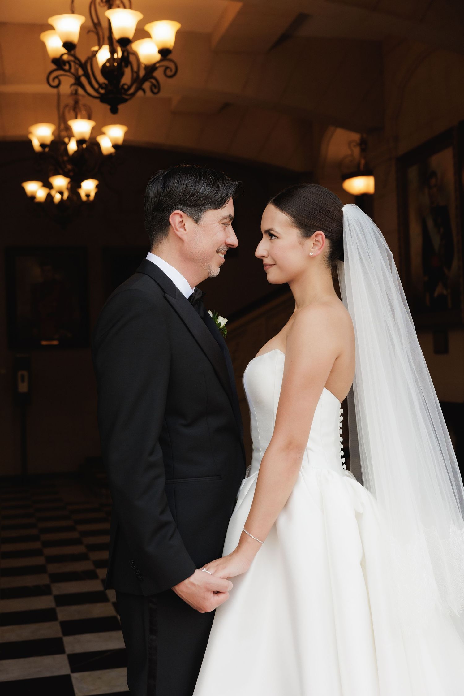 A romantic sequence of wedding photos showing a couple in a ballroom with ornate chandeliers and elegant decor.