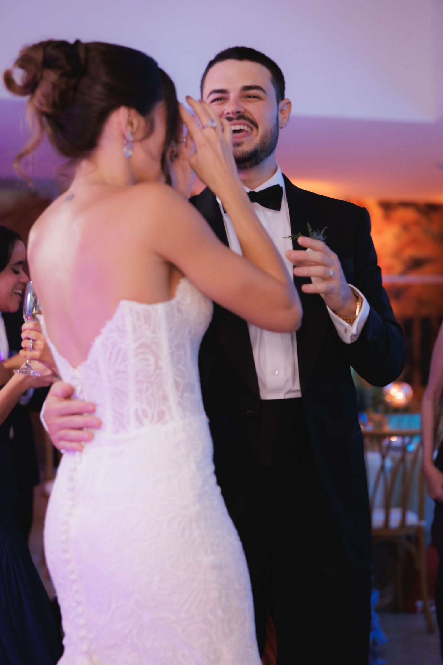 Elegant wedding celebration with couples dancing in formal attire under romantic lighting.