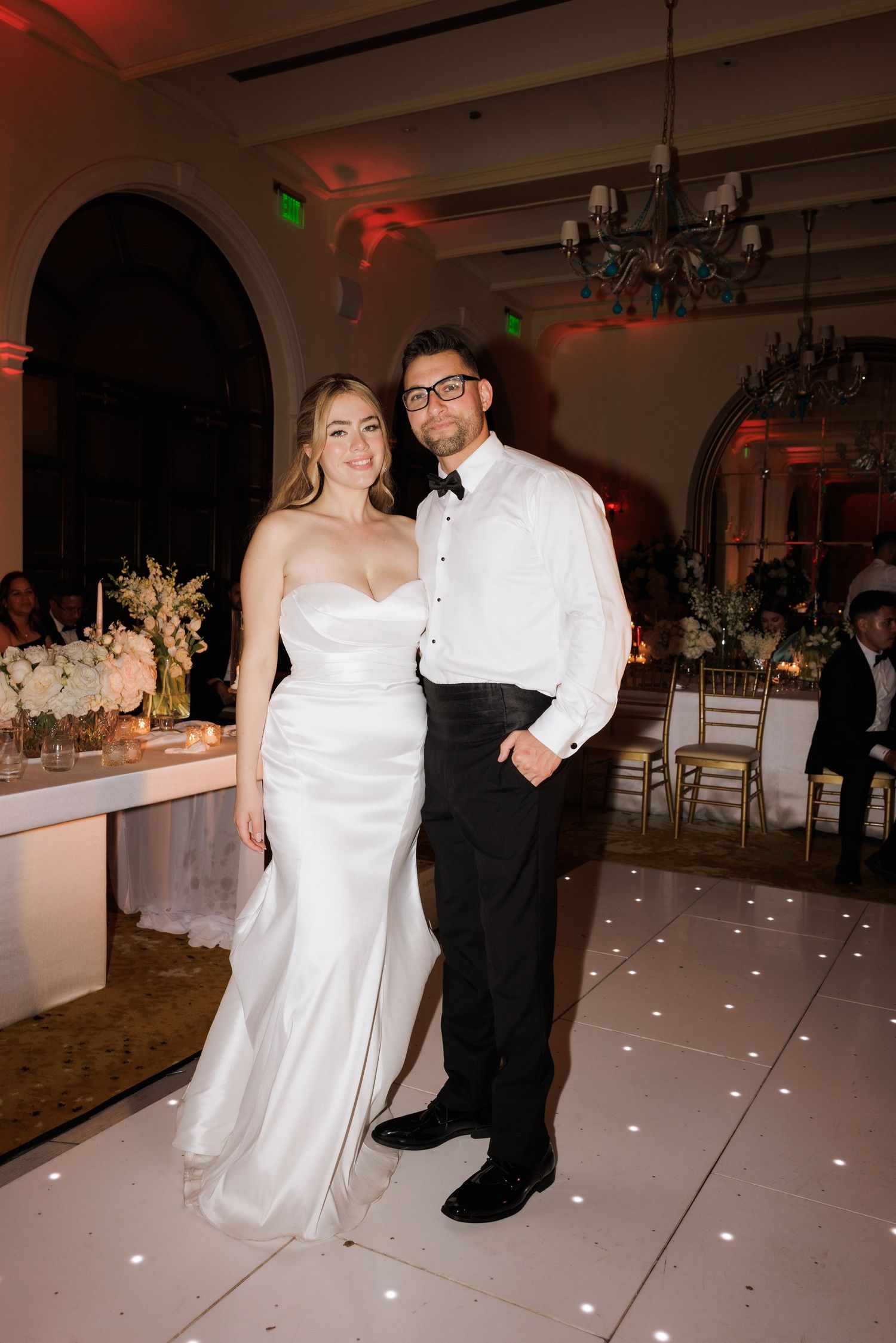 Wedding dance floor with red ambient lighting and white decorative elements.