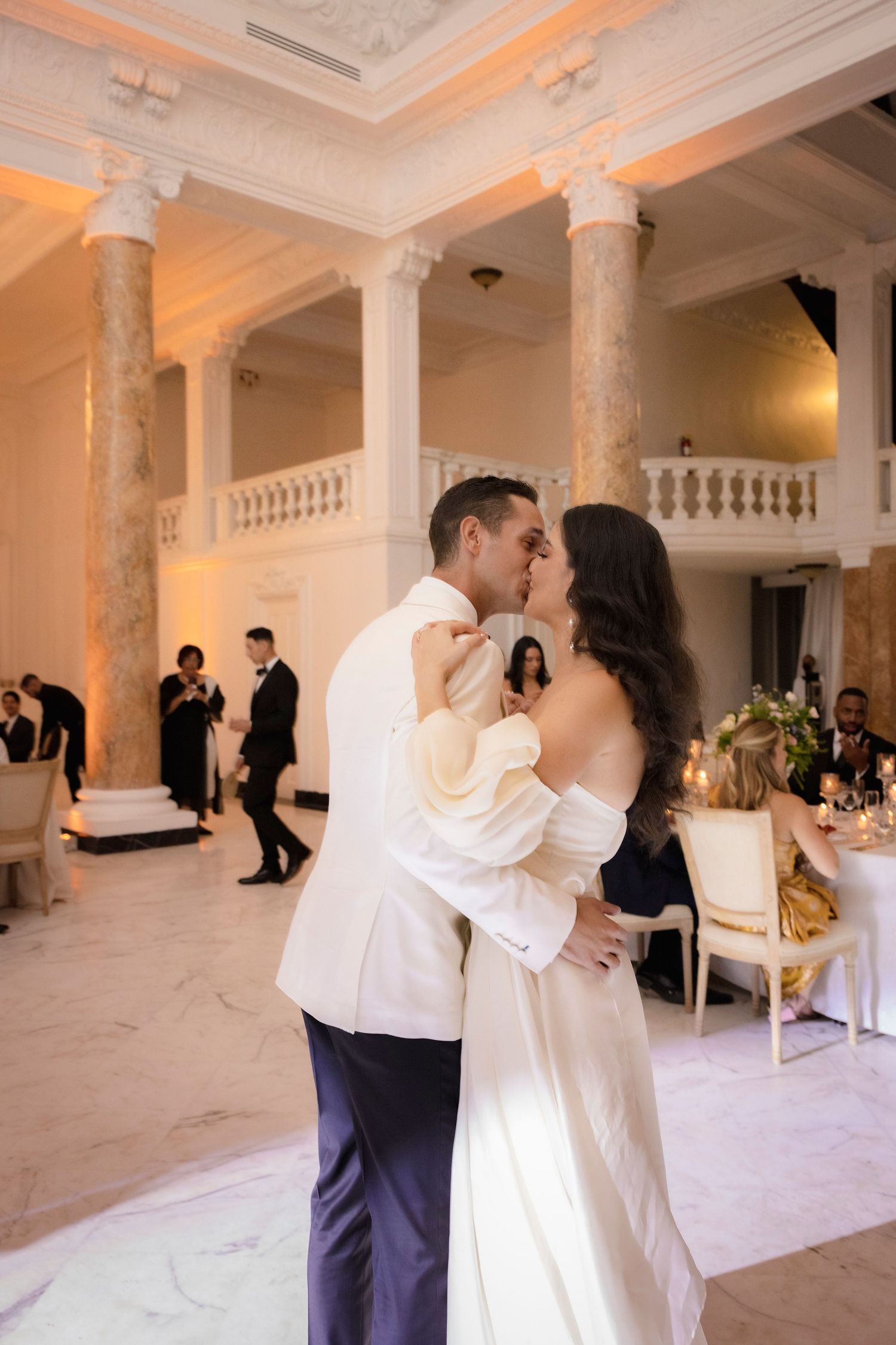 A romantic wedding dance sequence in an elegant white marble ballroom with ornate columns.