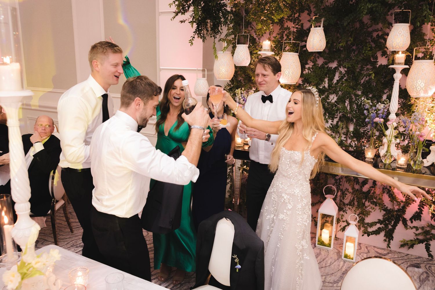 Wedding celebration in an elegantly decorated venue with hanging lanterns and greenery.