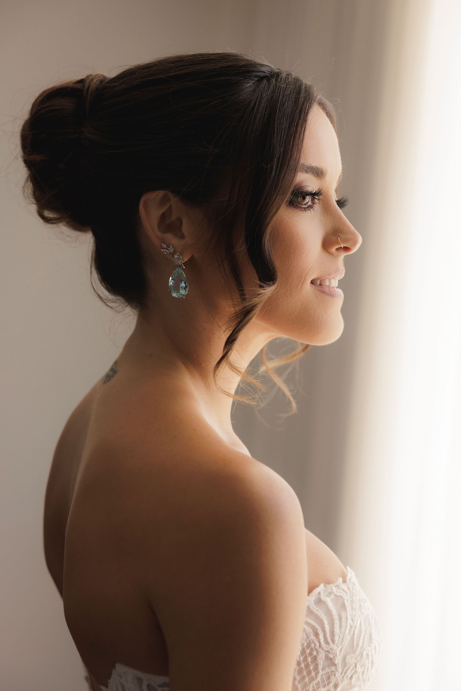 Silhouetted profile portraits of a bride with elegant updo hairstyle in natural window light.