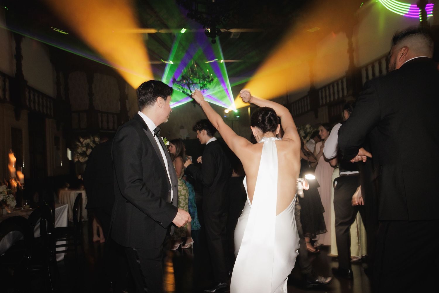 Wedding reception dance floor scene with colorful lighting and celebration in full swing.