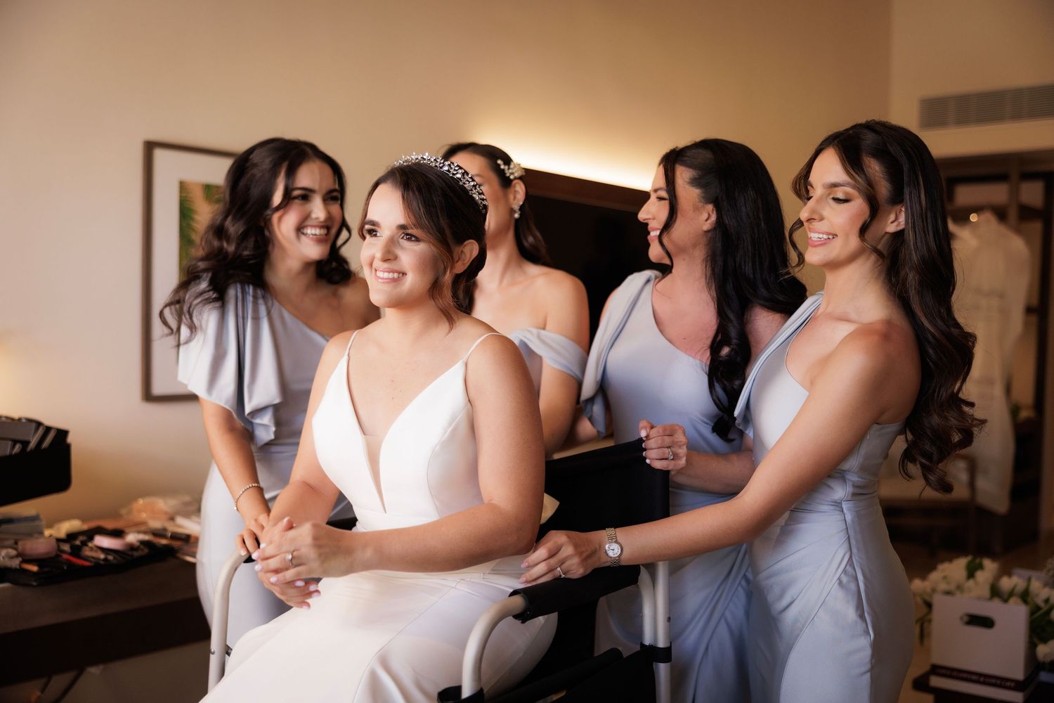 Wedding party having fun and laughing together while getting ready in a bright indoor setting.