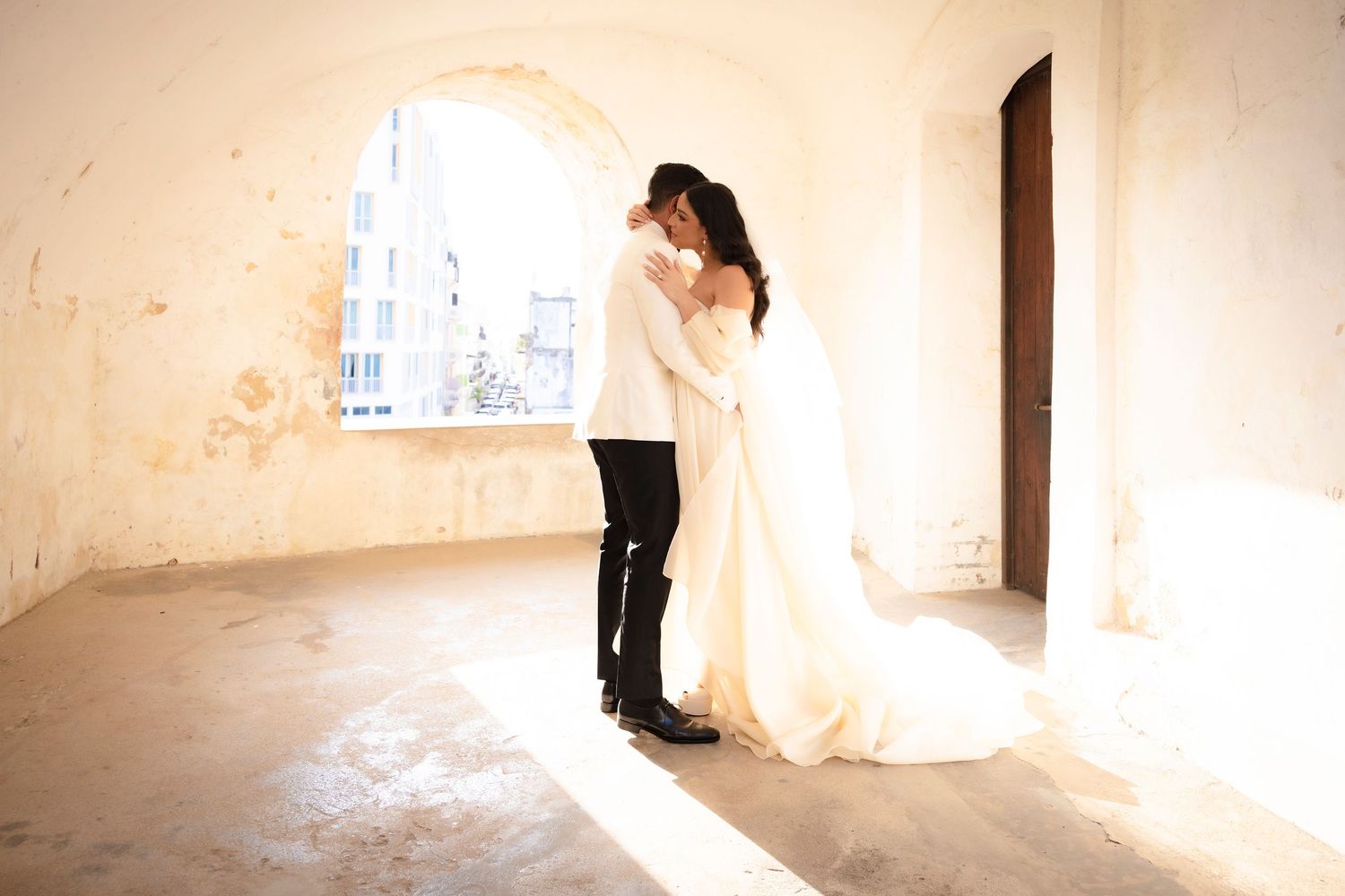 Ethereal wedding scene captured in warm tones against weathered walls.