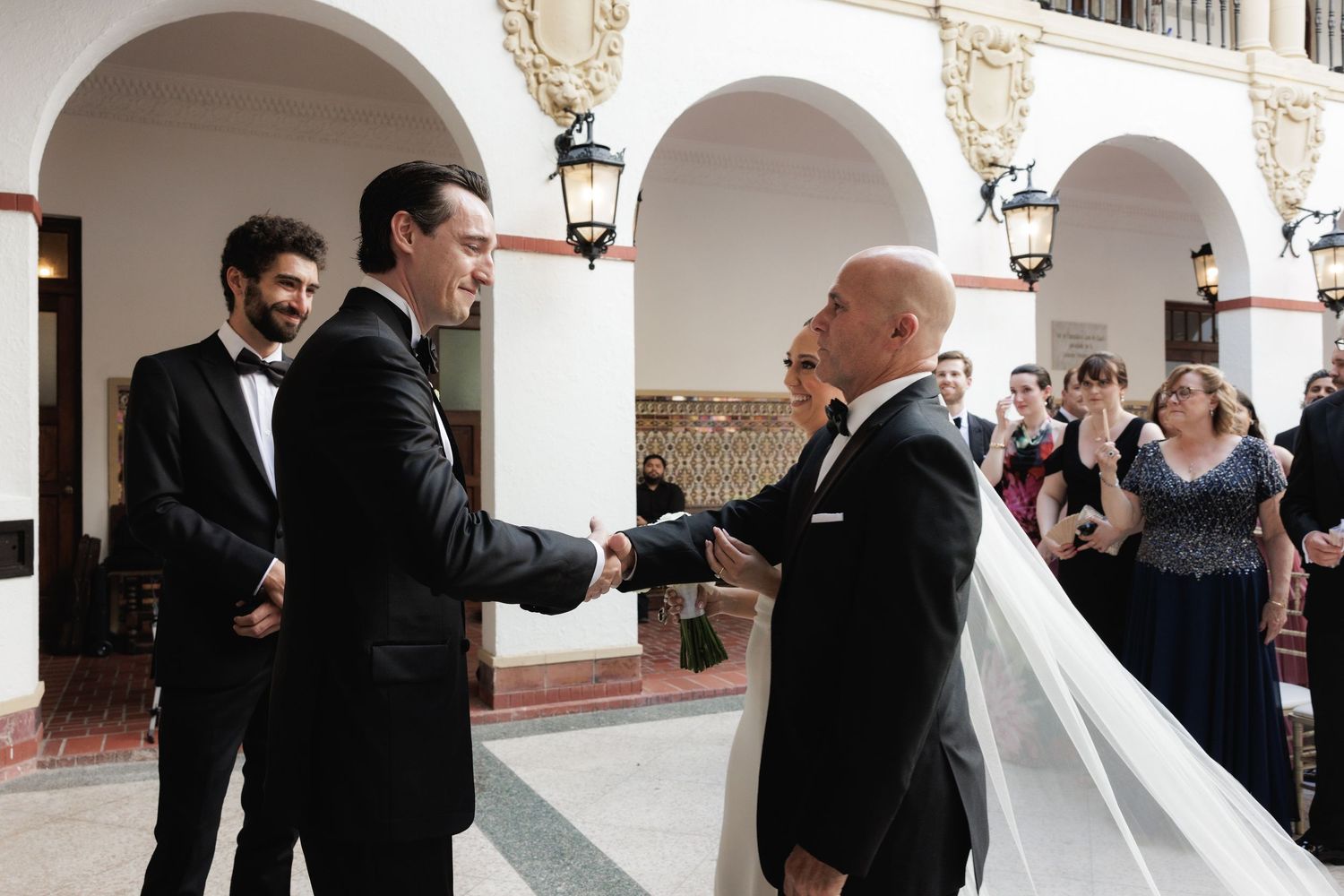 Bride and groom sharing an intimate moment during a wedding reception under elegant white archways.