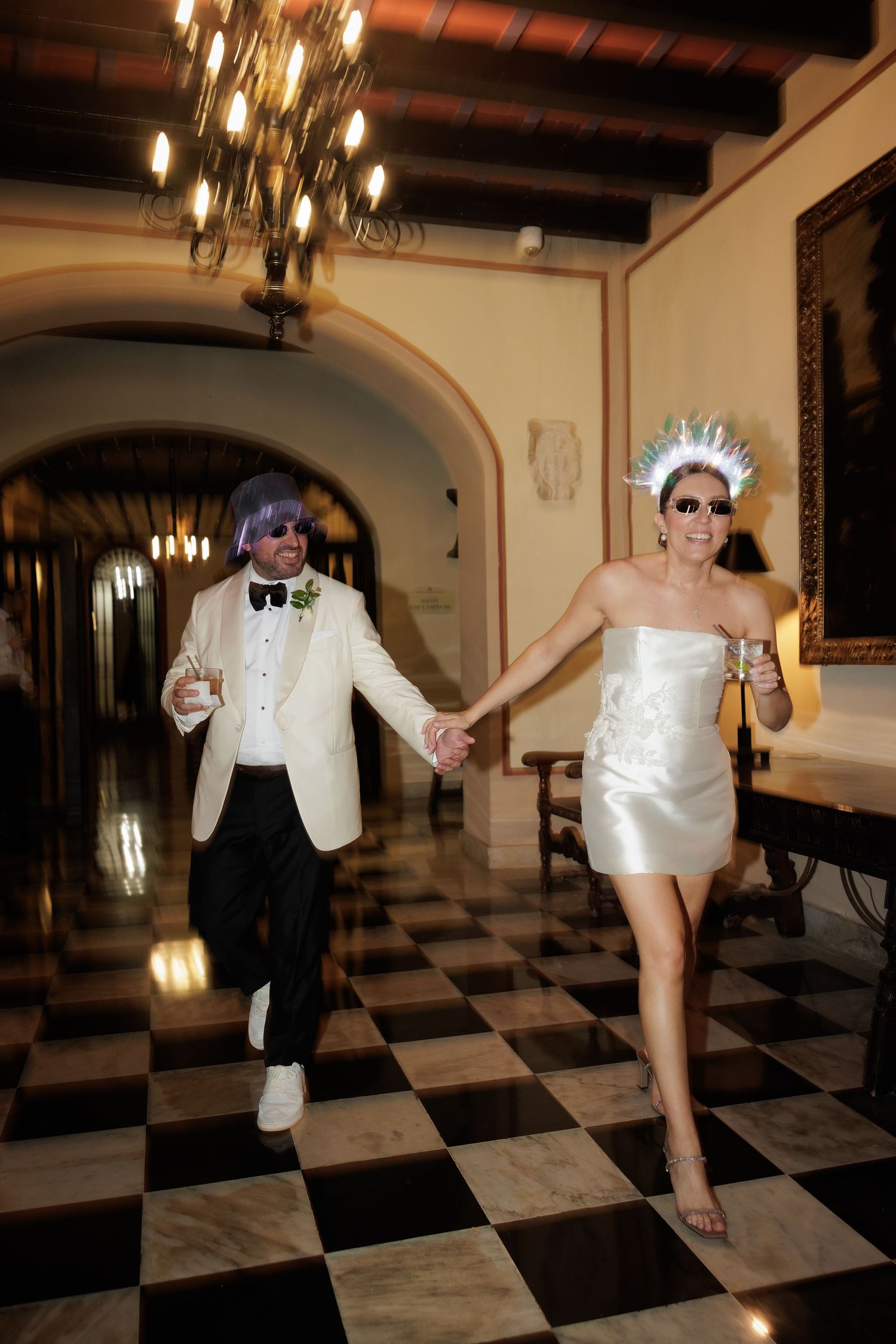Playful dance sequence on a checkered ballroom floor with dramatic lighting and arched doorways.