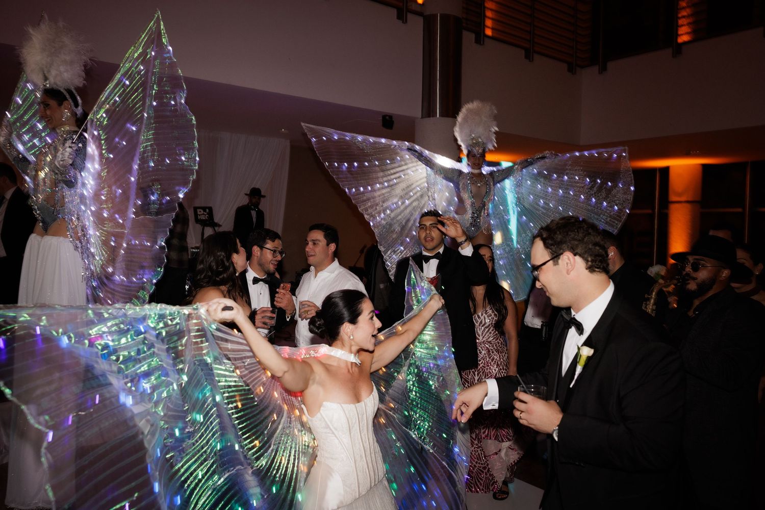 Wedding celebration featuring dancers with illuminated butterfly wings creating a magical atmosphere.