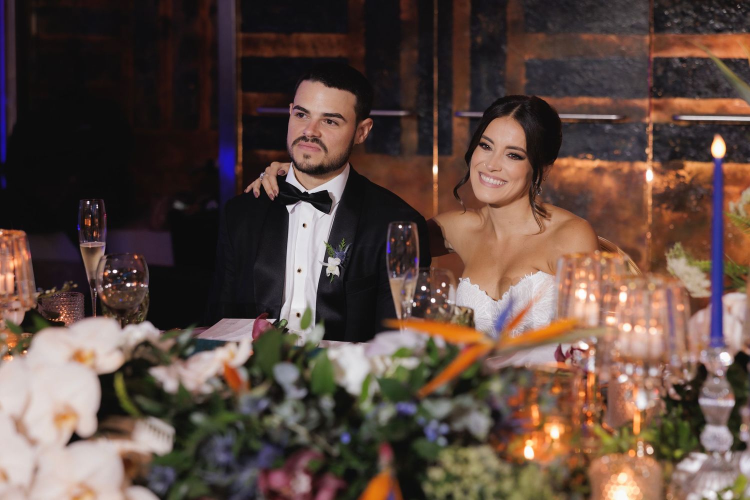 Wedding reception table decorated with candlelight, floral arrangements and glowing ambiance at an elegant evening celebration.