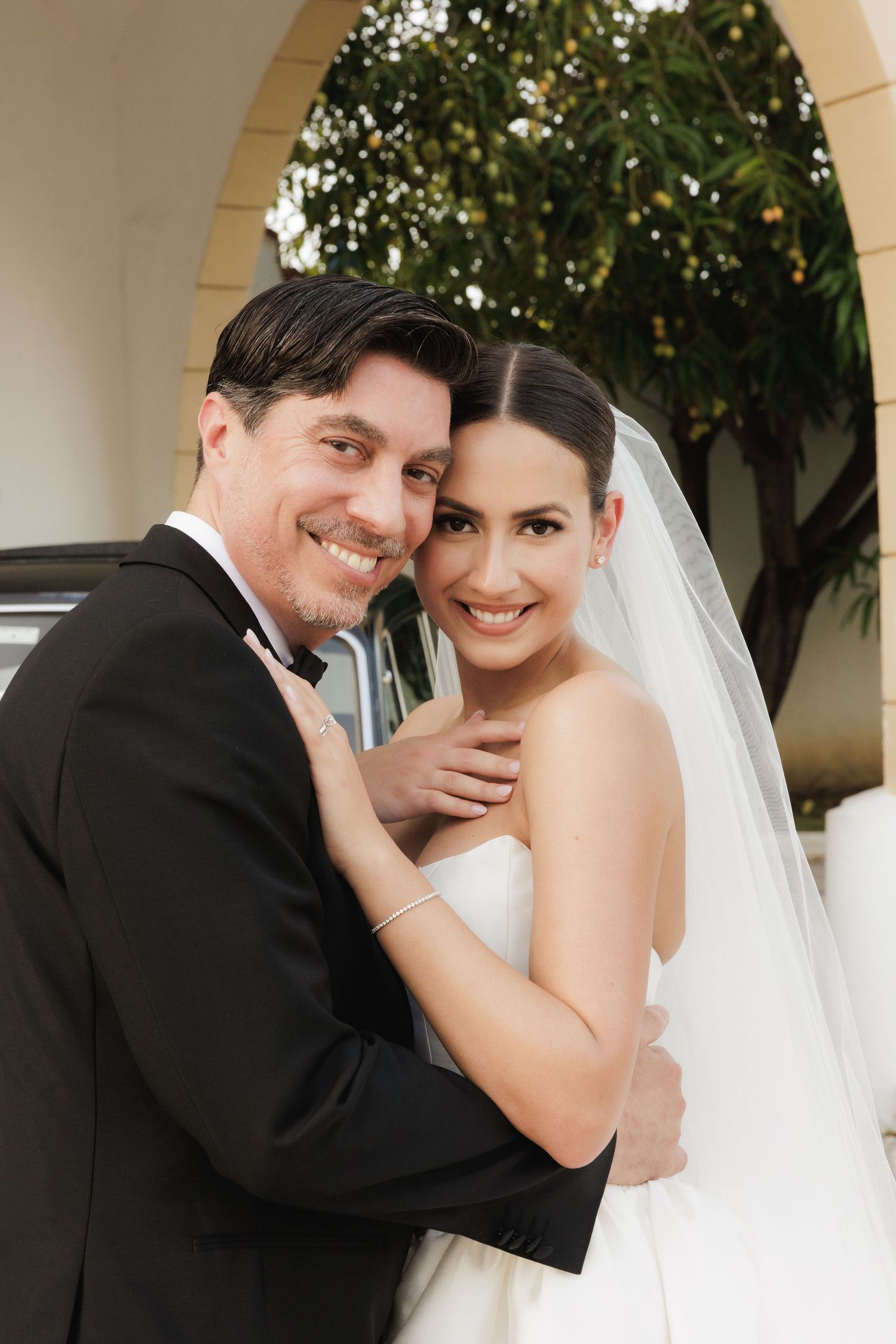 A romantic wedding portrait series showing tender moments between newlyweds under a covered walkway.