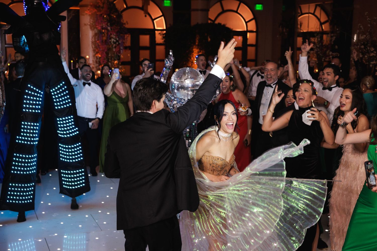Dance party with colorful LED lights illuminating the dance floor as guests celebrate.