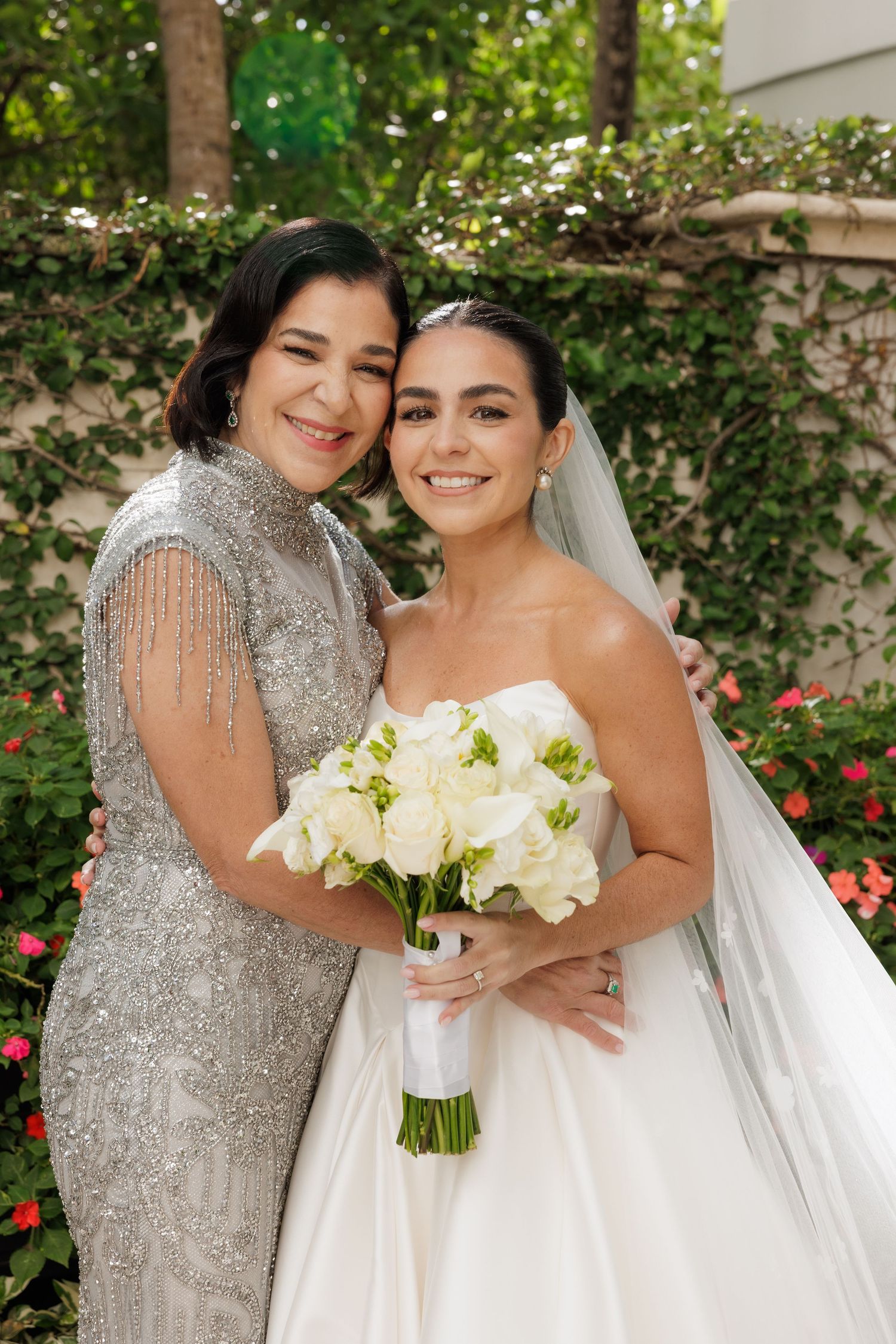 An elegant wedding scene with a sparkling silver dress and white floral bouquet in a garden setting.