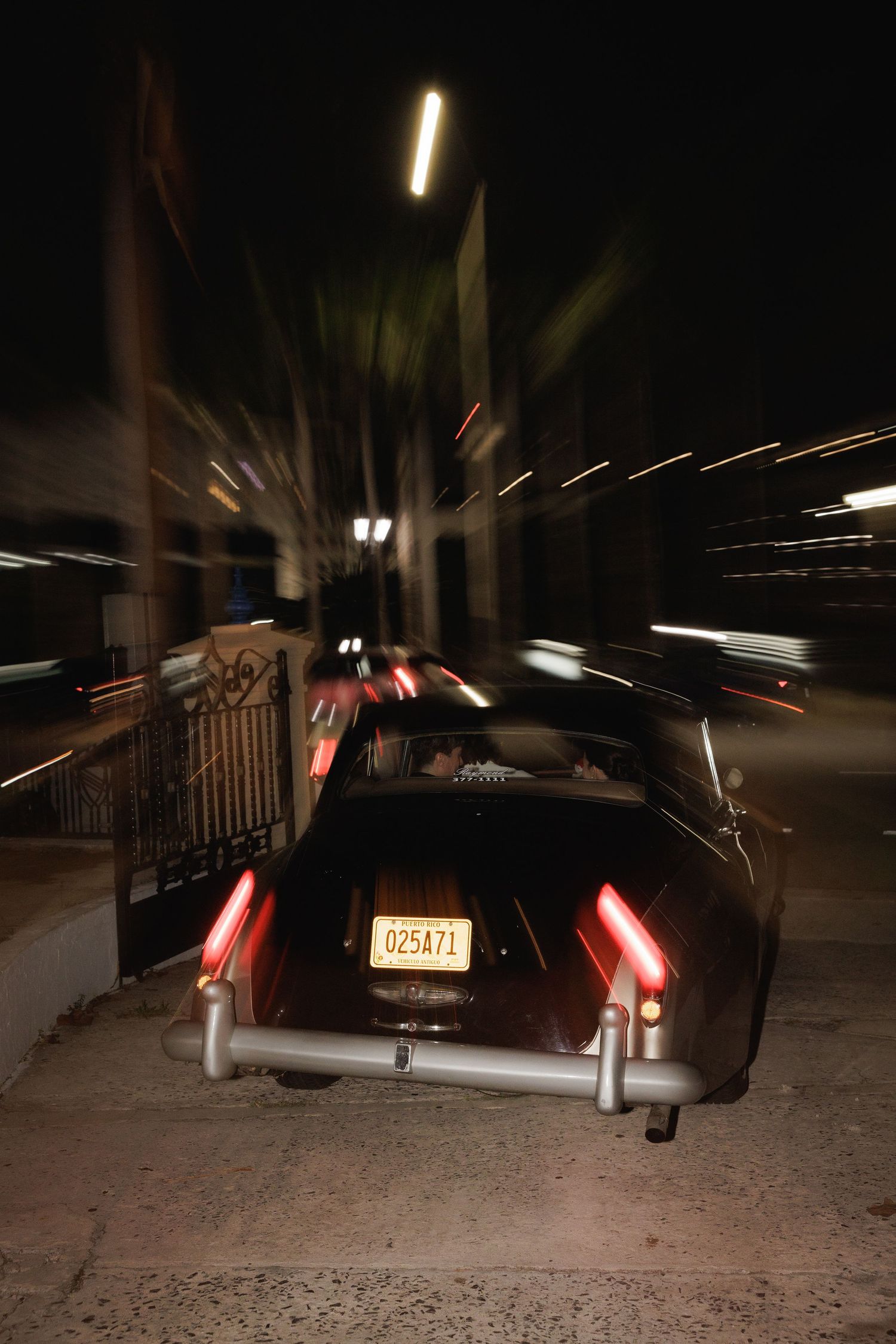 Blurred motion shot of car taillights at night creating light trails.