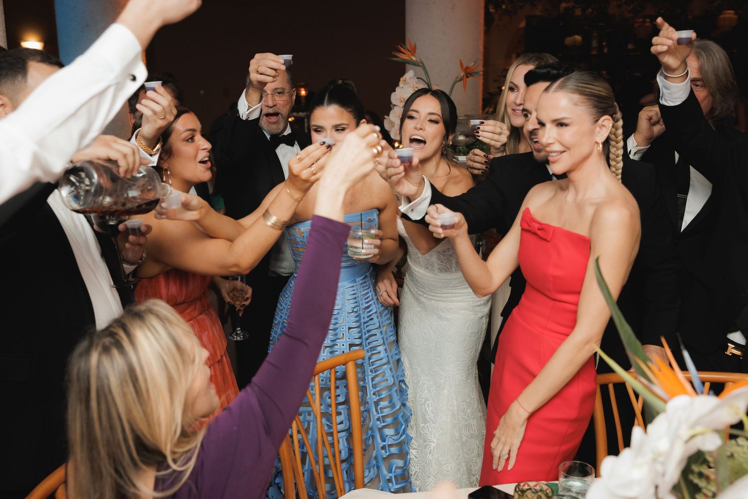 Party guests enjoying themselves on a dance floor at an evening celebration with dramatic lighting.