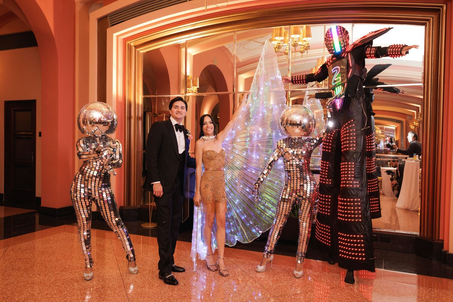 Crystal chandeliers and warm lighting create an elegant ambiance in a luxurious ballroom-style hallway setting.