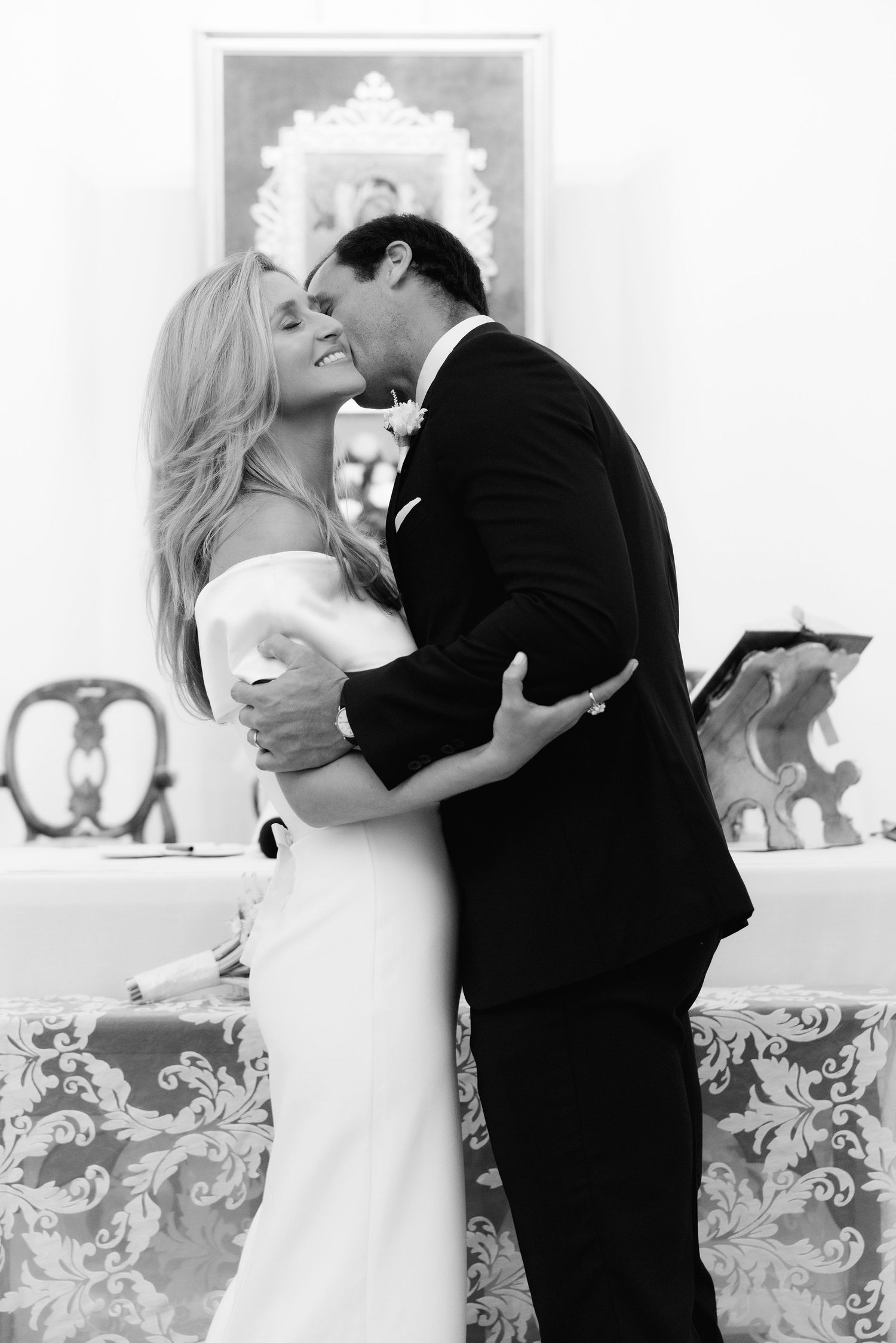 A black and white romantic wedding photo showing an intimate moment between a couple sharing their first dance.