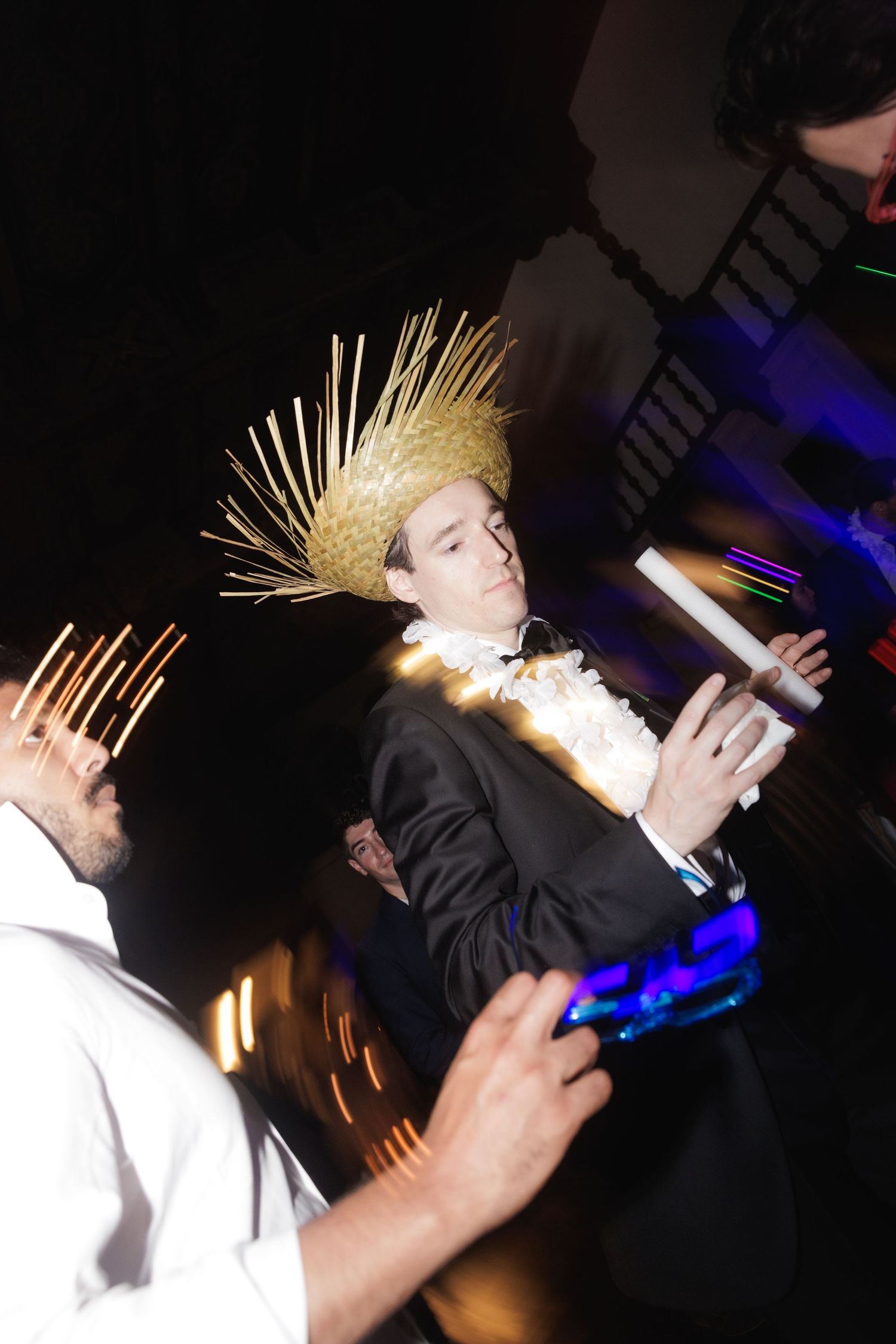People dancing at a party with unique spiky hairstyles and glowing blue lights in a dark setting.