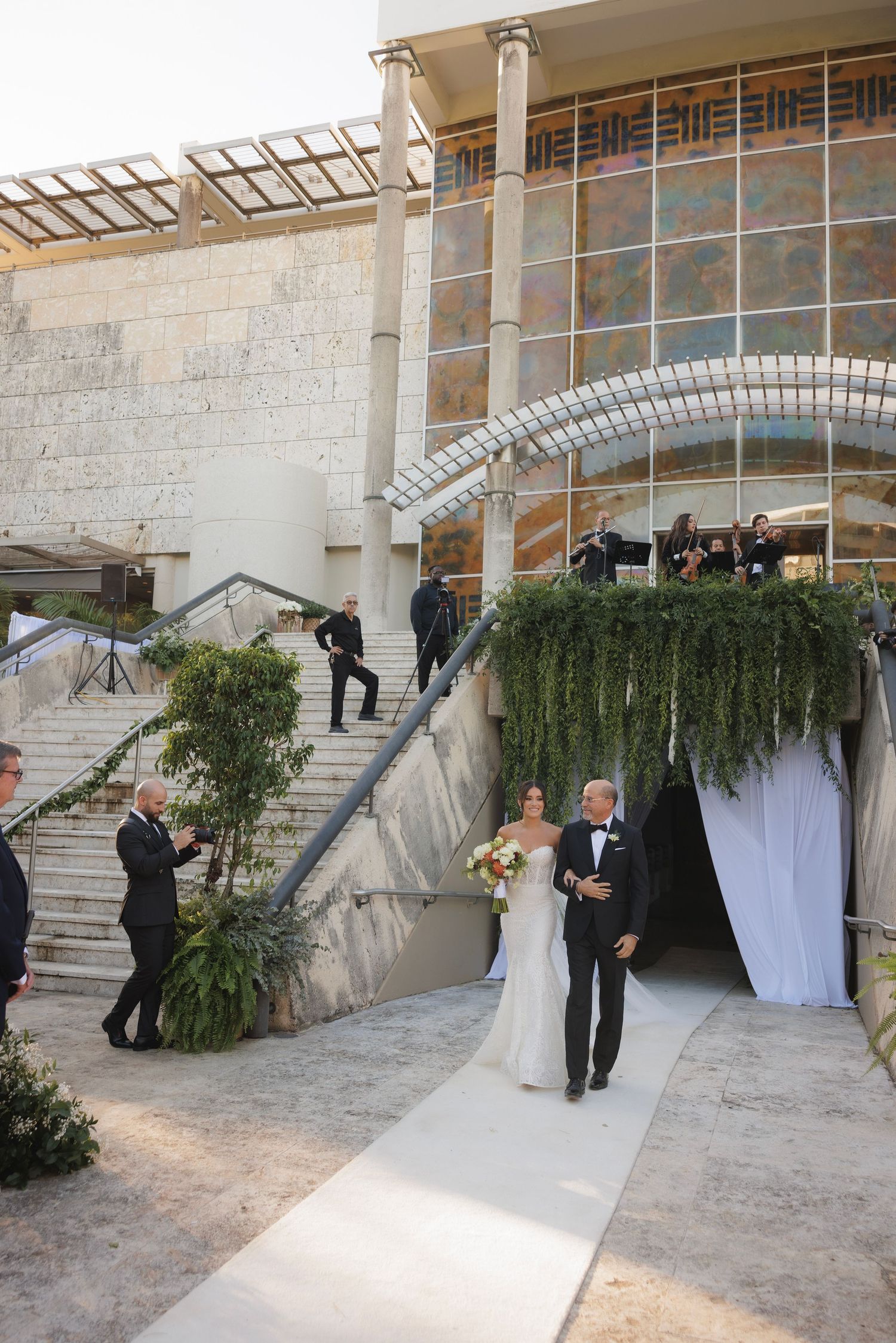 A wedding ceremony entrance with white stone columns and draped fabric creating an elegant archway.