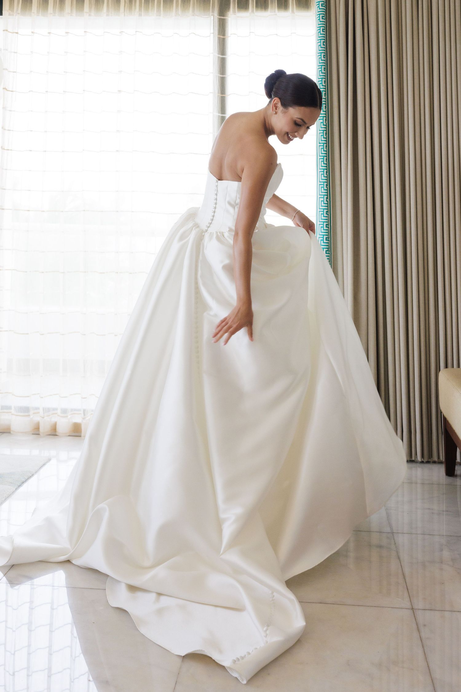 Bride in flowing white ballgown shows movement and detail of dress in natural light.