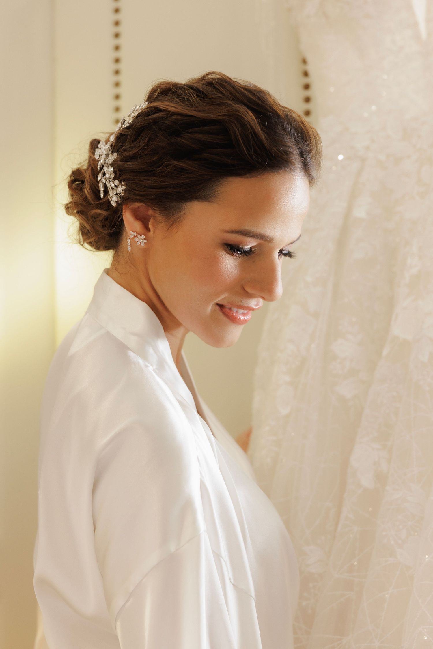 A bride in white getting ready before her wedding, shown in a series of romantic soft-lit photos.