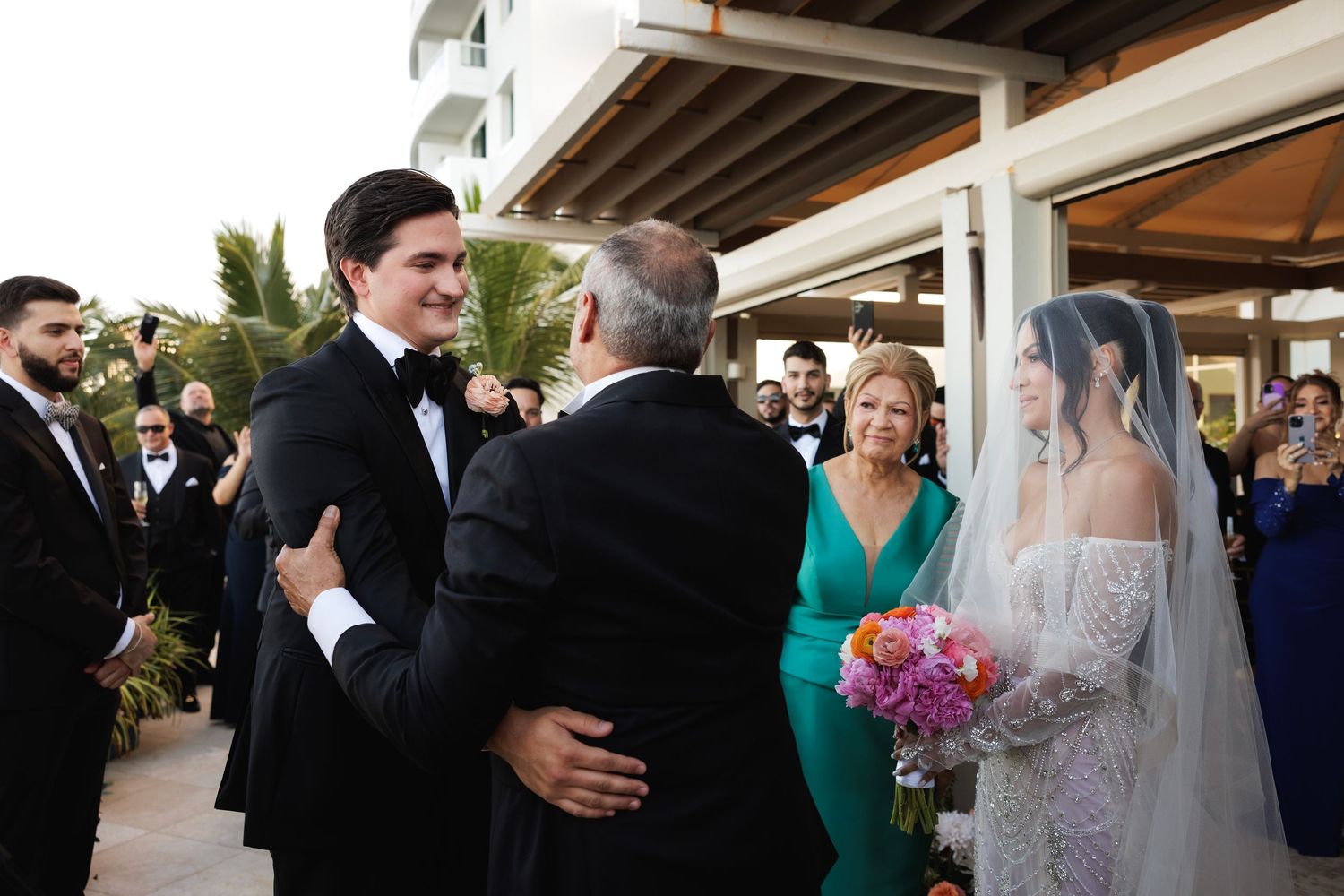 Wedding ceremony at an outdoor venue with guests gathered for a special moment at sunset.