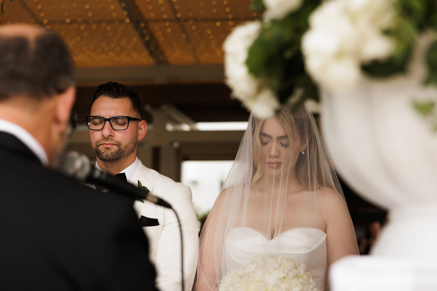 Black and white photo series of a romantic wedding ceremony with the couple exchanging vows indoors.