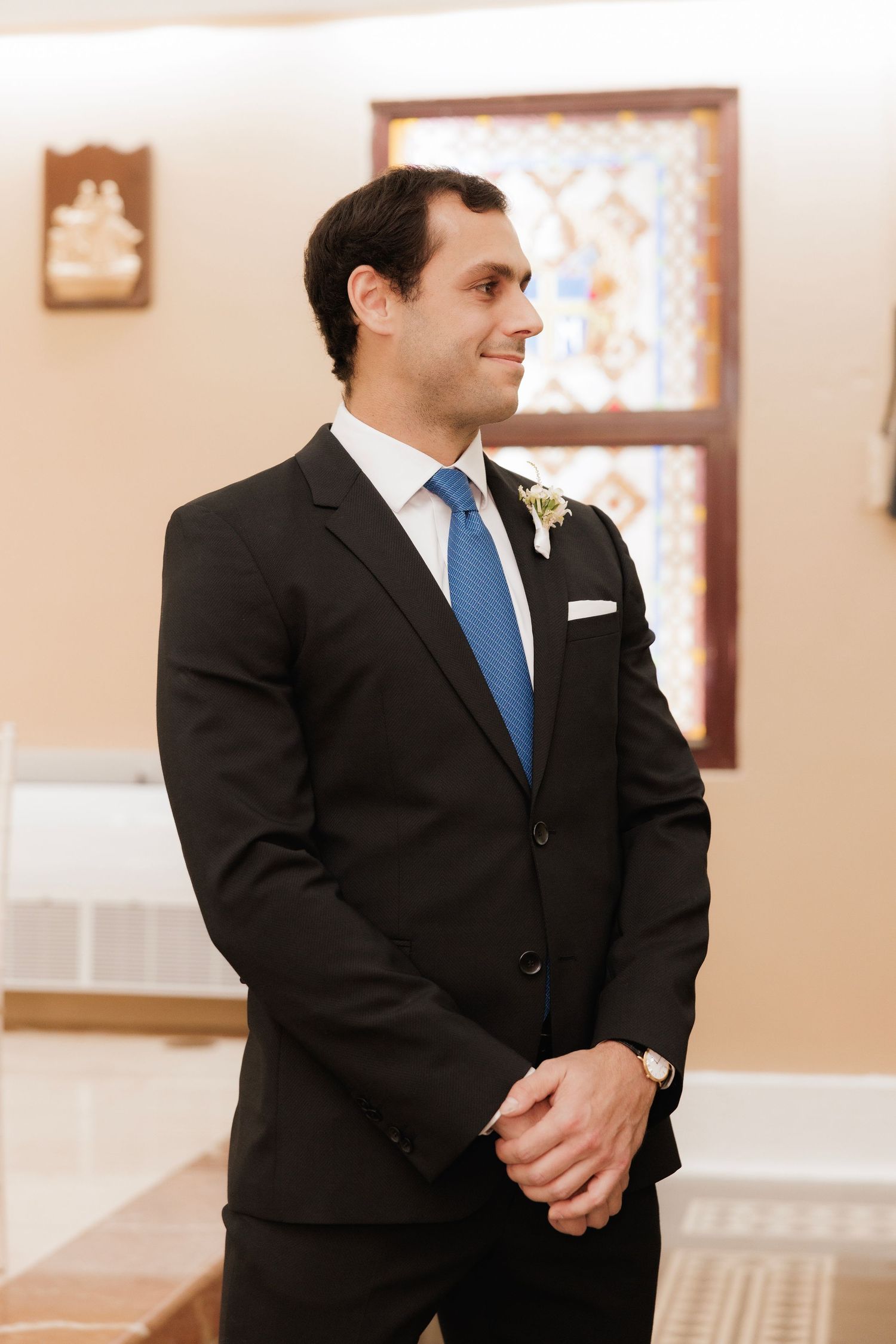 Four similar photos show someone in a black suit with a blue tie standing at what appears to be a formal event.