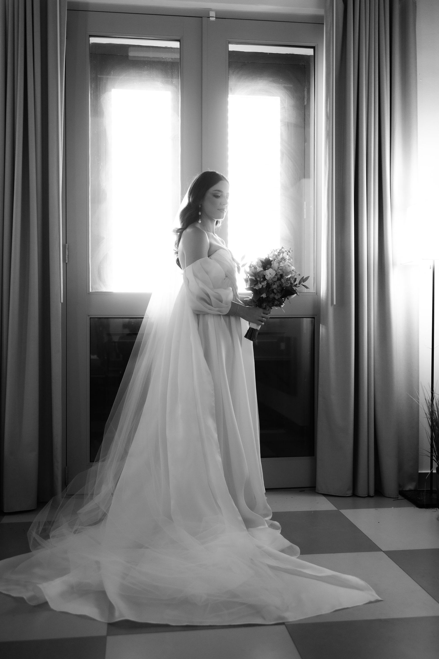 Black and white photos of a dramatic wedding gown with flowing train in a sunlit room.