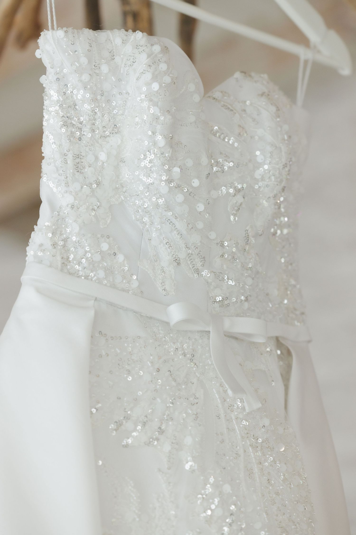Detail shots of a white wedding dress with intricate beading and sequins.