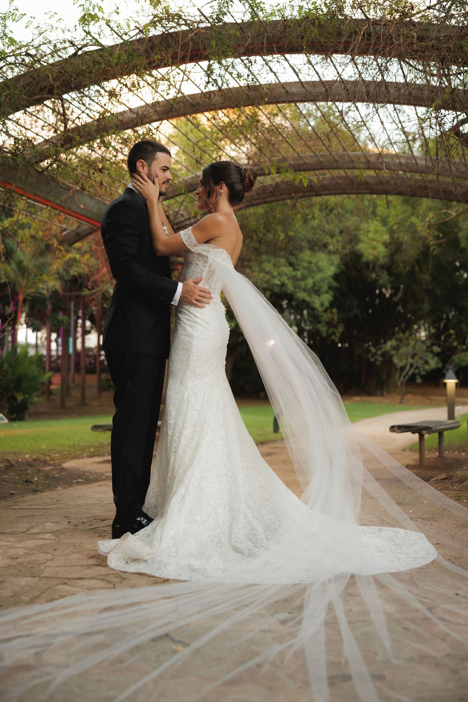 A romantic wedding photoshoot sequence showing a couple dancing under a rustic wooden pergola in a garden setting.