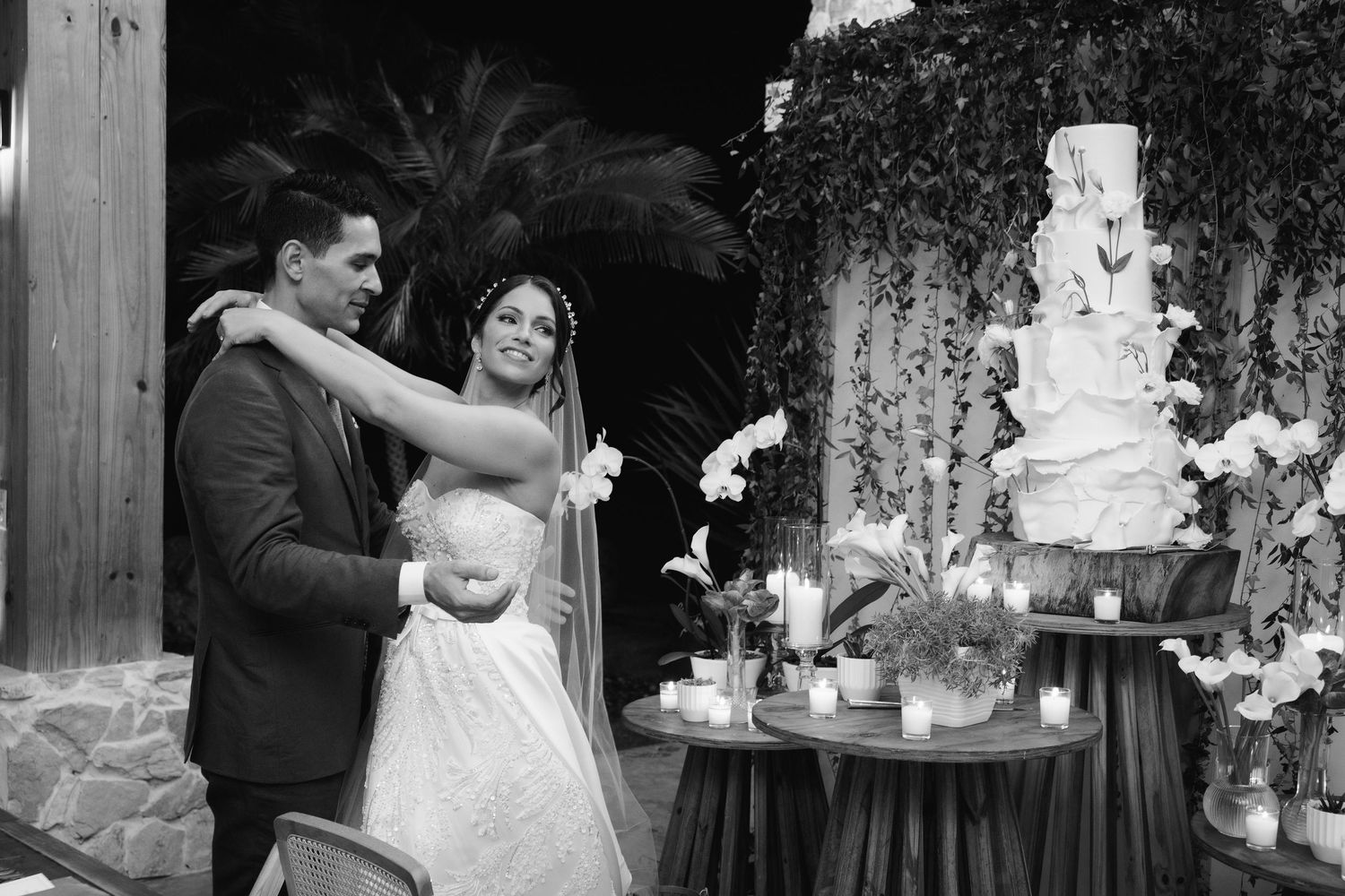 A collage of black and white wedding photos showing couples dancing, cake cutting, and romantic moments at a reception.