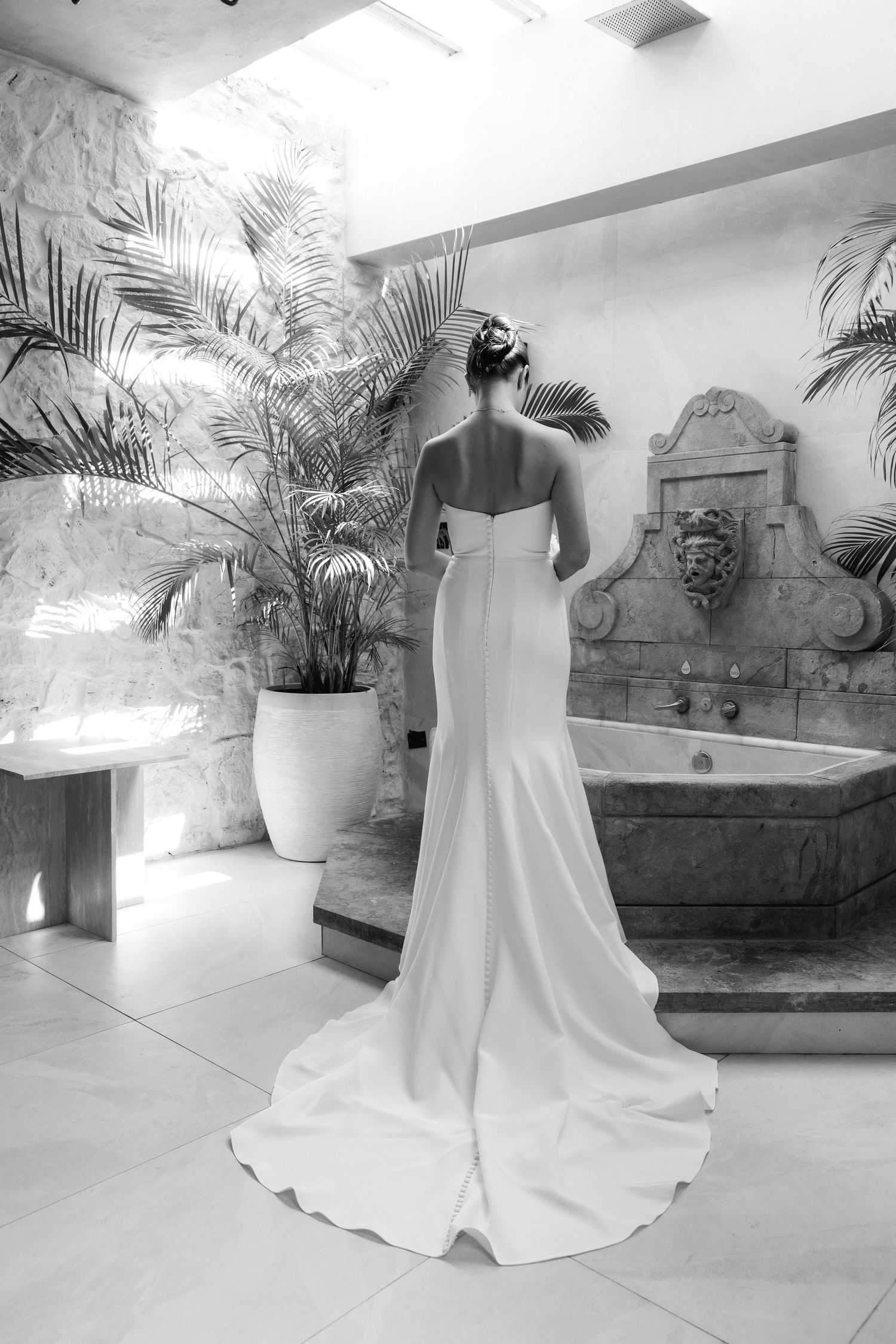 Elegant floor-length white bridal gown displayed from different angles in a luxurious venue with palm plants and ornate decor.