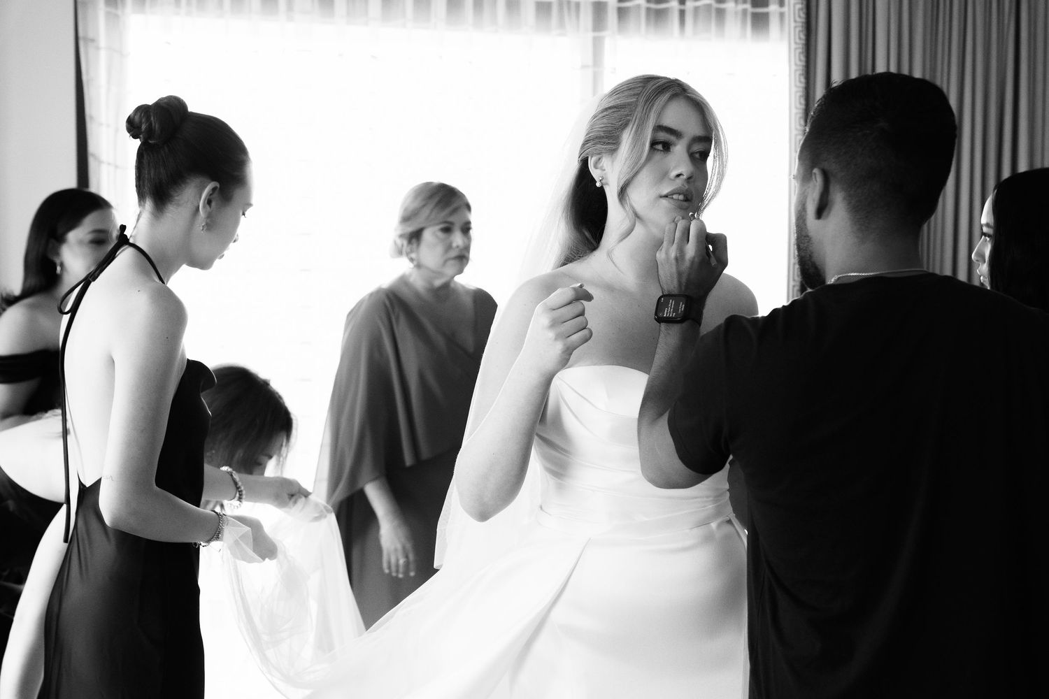 A series of black and white wedding photos showing intimate moments between couples and guests during a celebration.
