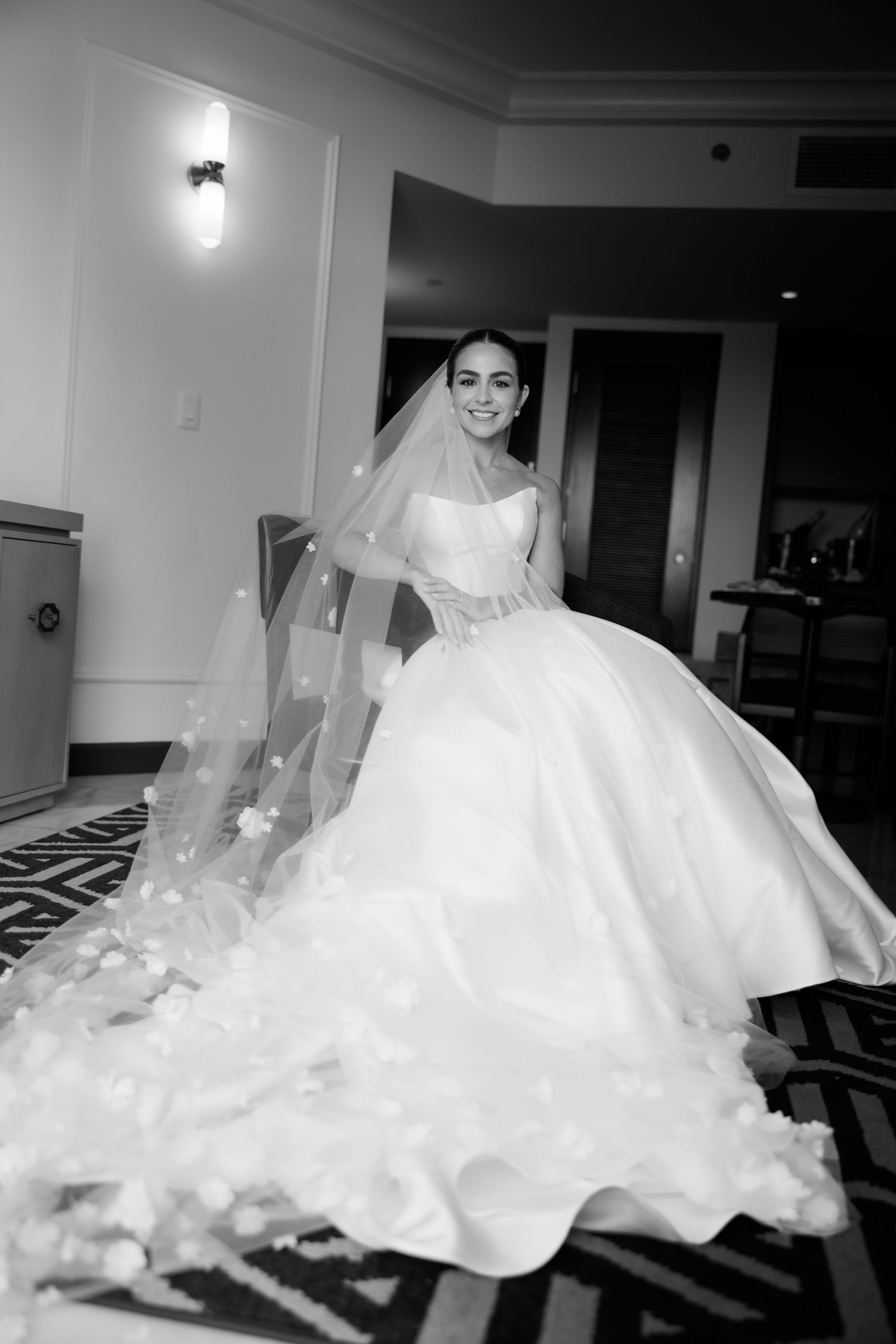 Flowing white wedding dress captured in motion against dark background creating dramatic silhouette effect.