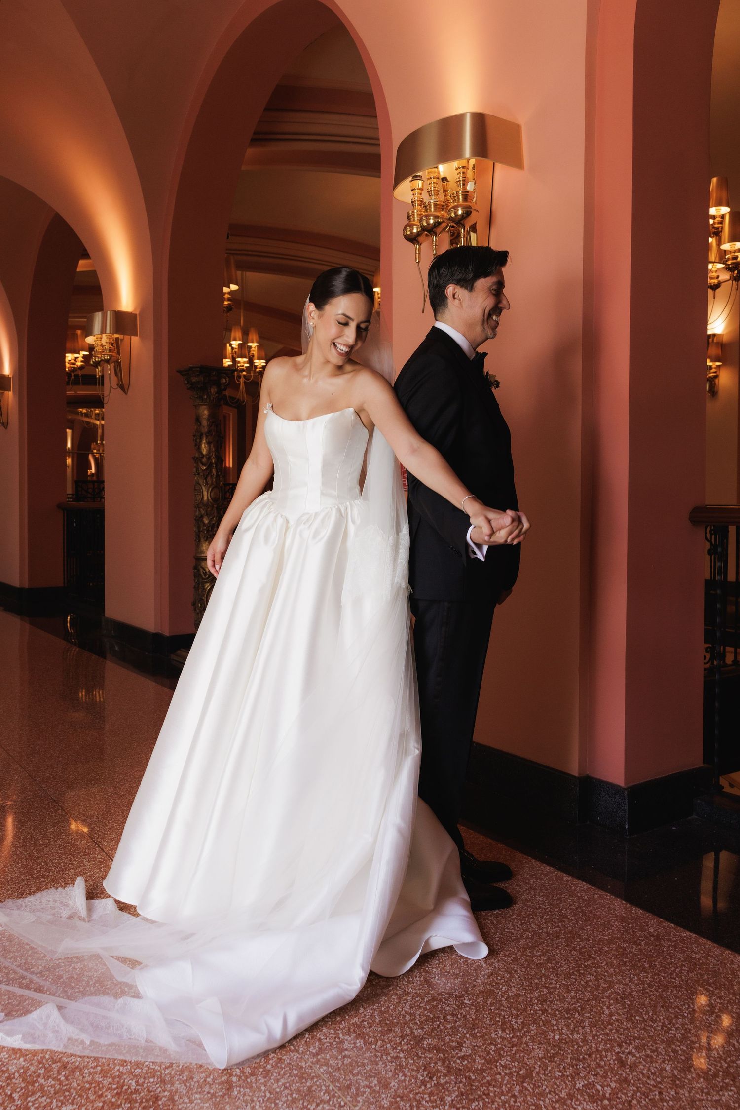 A sequence of wedding photos showing a couple in formal attire walking through an elegant hallway with pink walls.