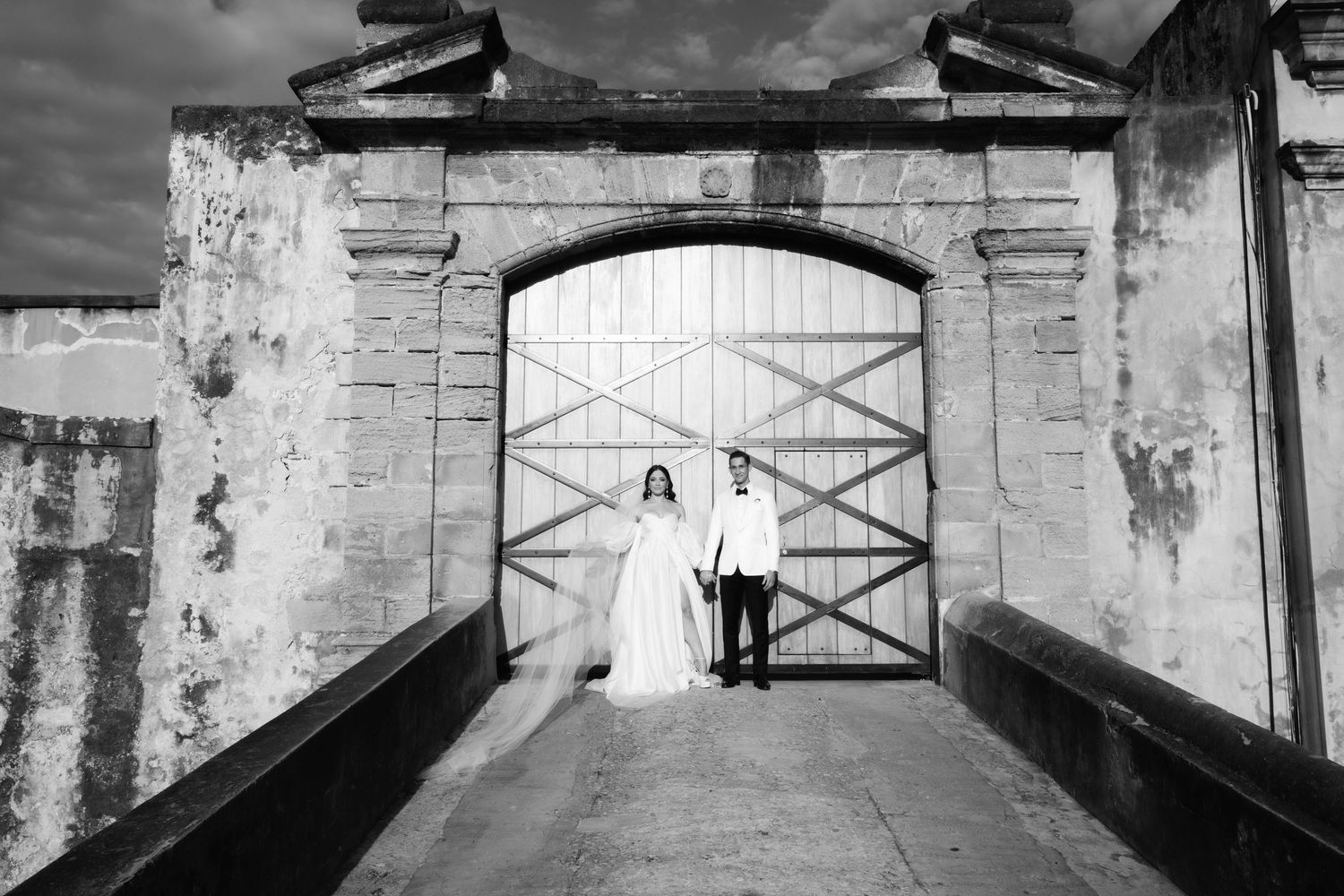 Black and white architectural shots of historic stone walls with cross-braced gates.