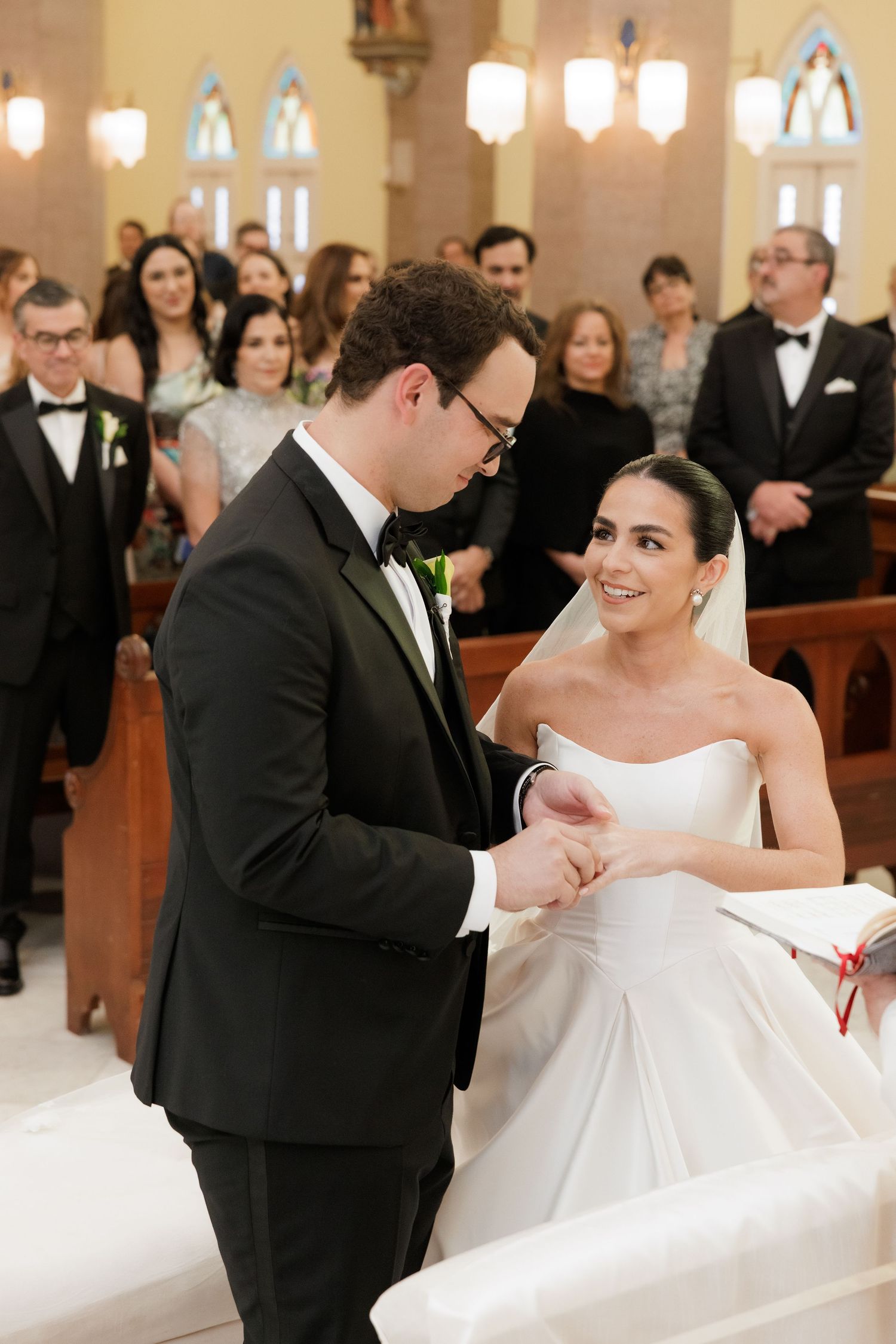 Wedding couple sharing a joyful moment during their ceremony in a beautiful church sanctuary.