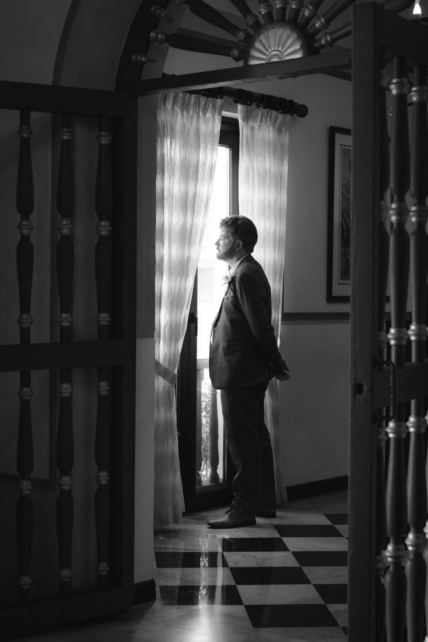 Dramatic black and white hallway scenes with silhouettes against window light and ornate bannisters.