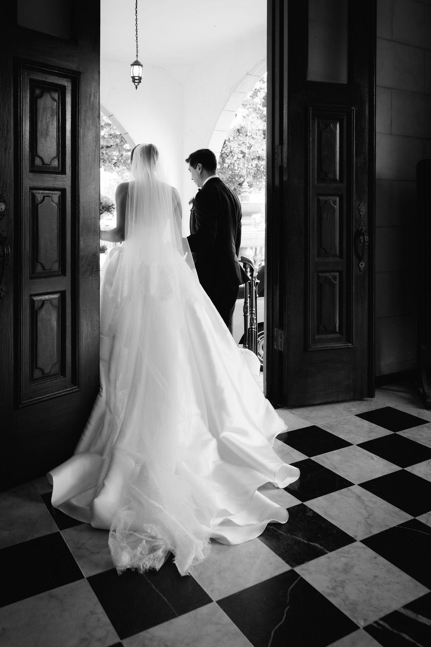 Black and white sequence showing a flowing wedding dress train on a checkered floor.