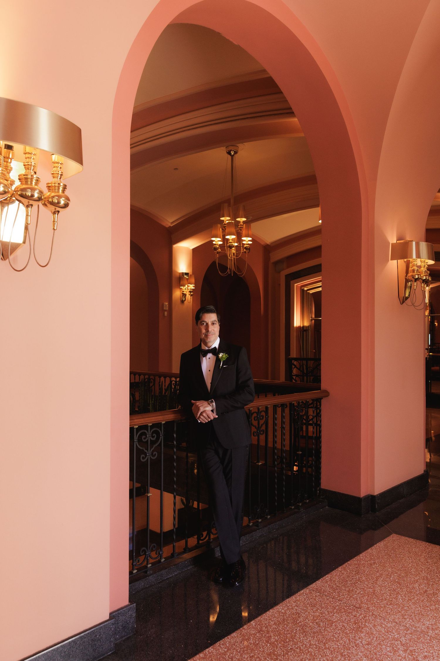A sequence of silhouettes in an arched hallway with warm lighting and elegant architectural details.