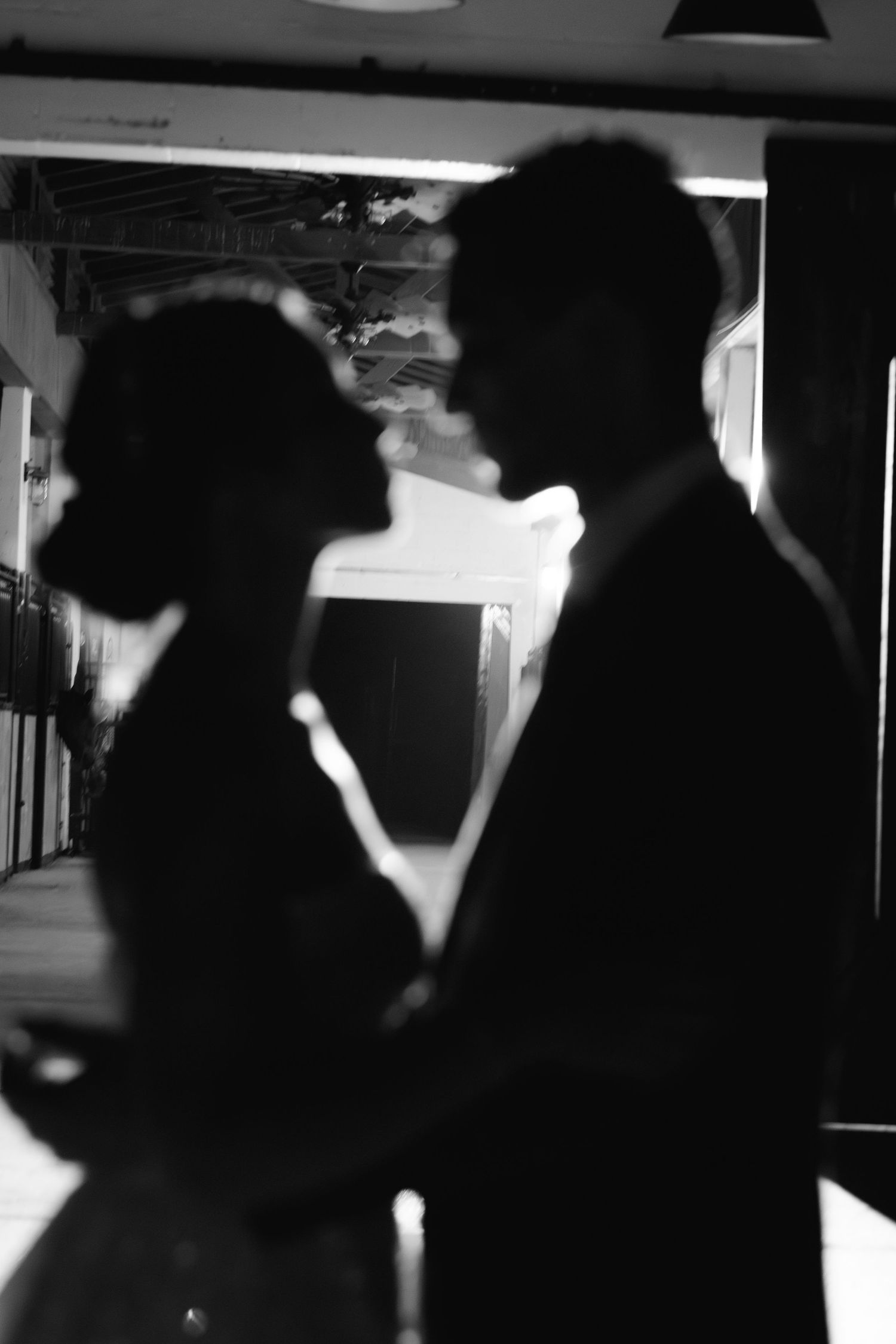 Silhouettes of a dancing couple in dramatic black and white lighting.