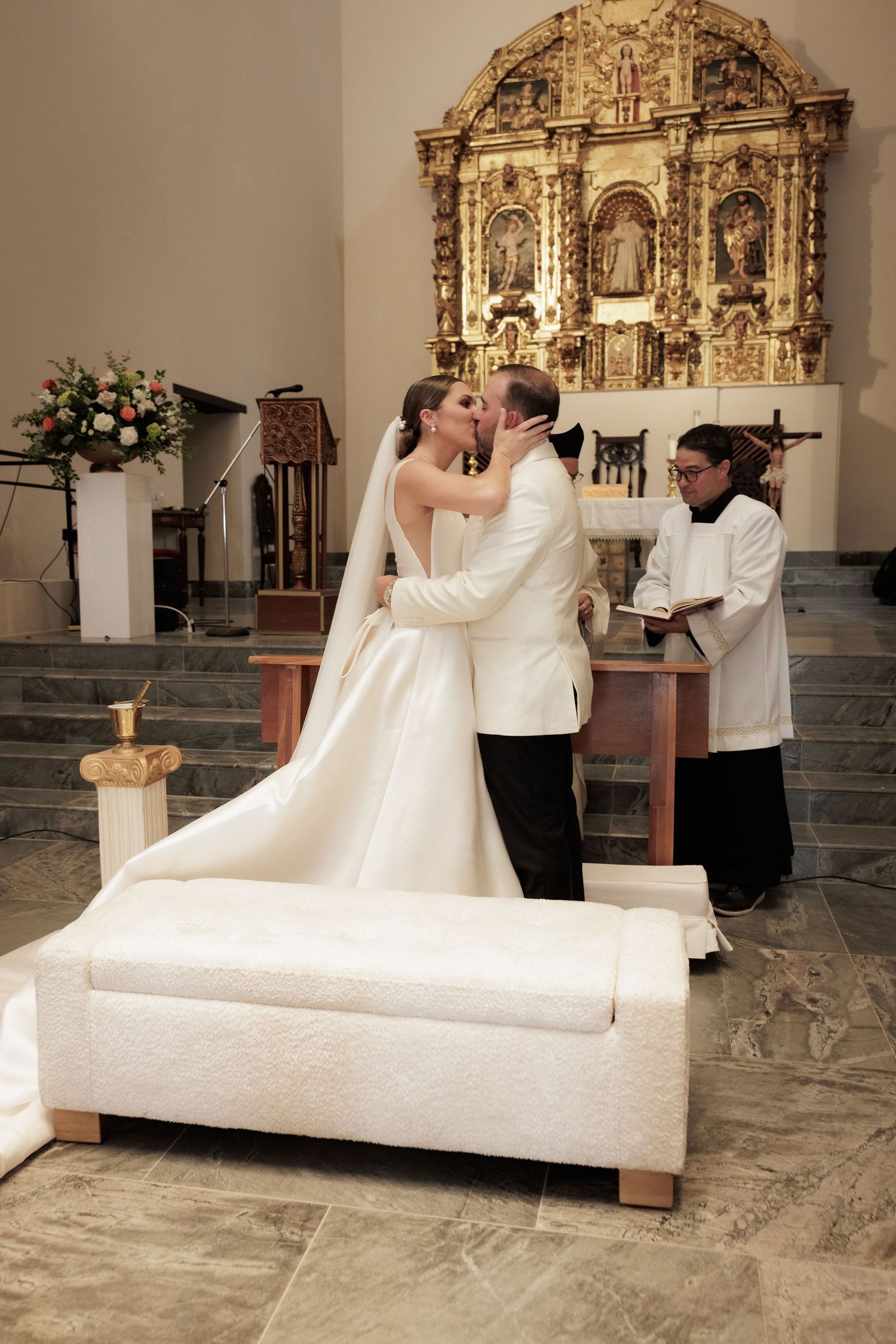 Wedding ritual taking place at an ornate church altar with gold decorative elements.