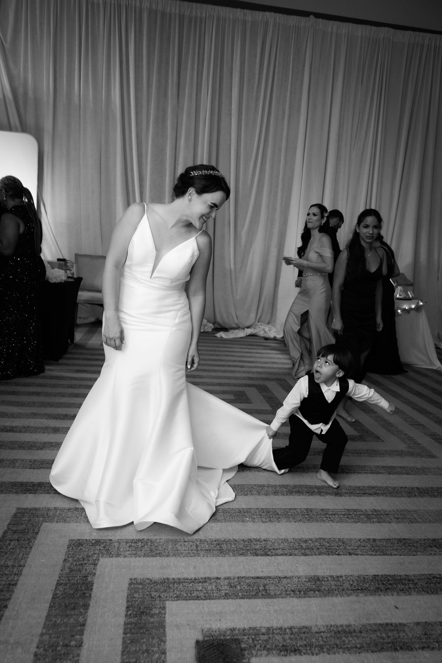A black and white photo series shows a graceful dance sequence between two figures on a striped floor.