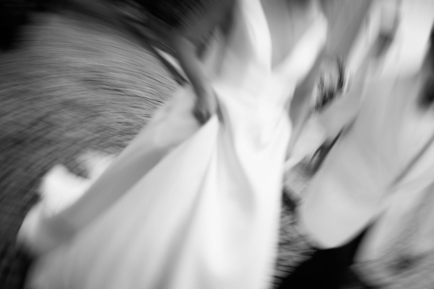 Abstract black and white photograph with blurred motion creates a dynamic swirling pattern of light and shadow.