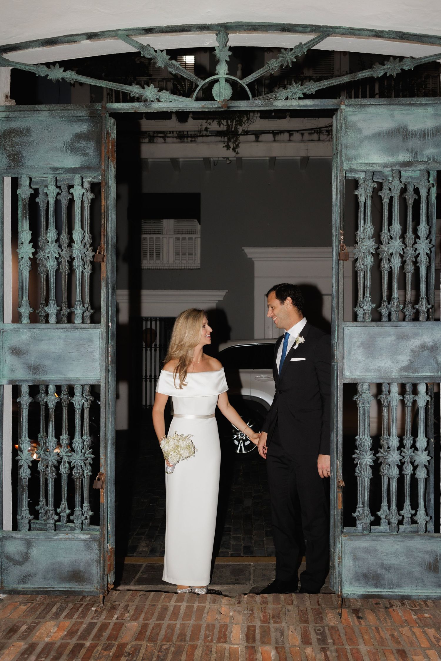 A romantic couple shares intimate moments against a backdrop of vintage wooden doors during an indoor photo session.