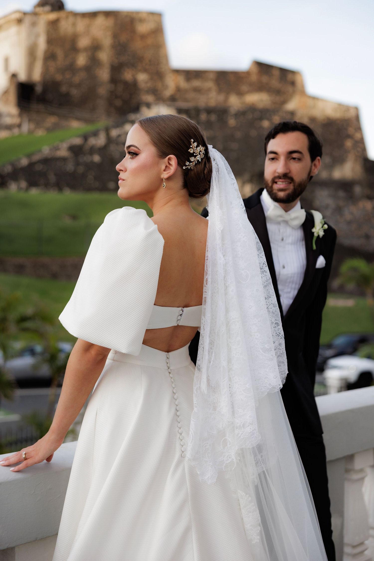 A series of wedding photos capturing sweet moments between a couple in white dress and black tuxedo against stone walls.