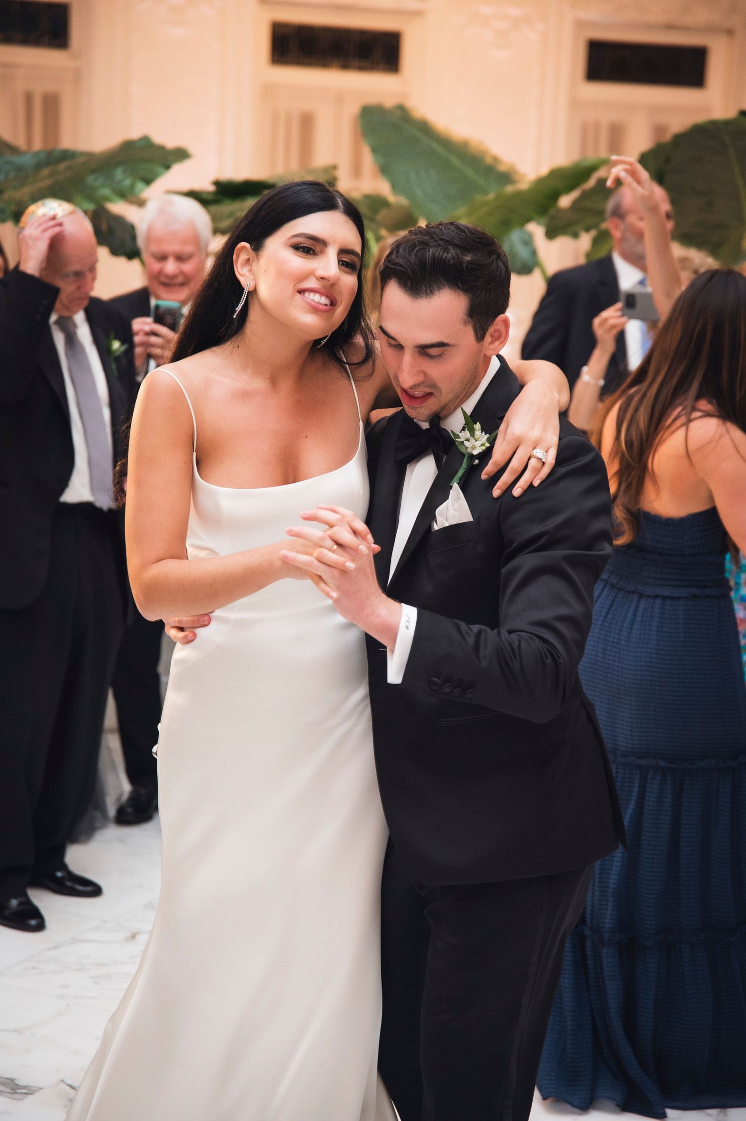 Couples dance together at an elegant wedding reception in formal attire.