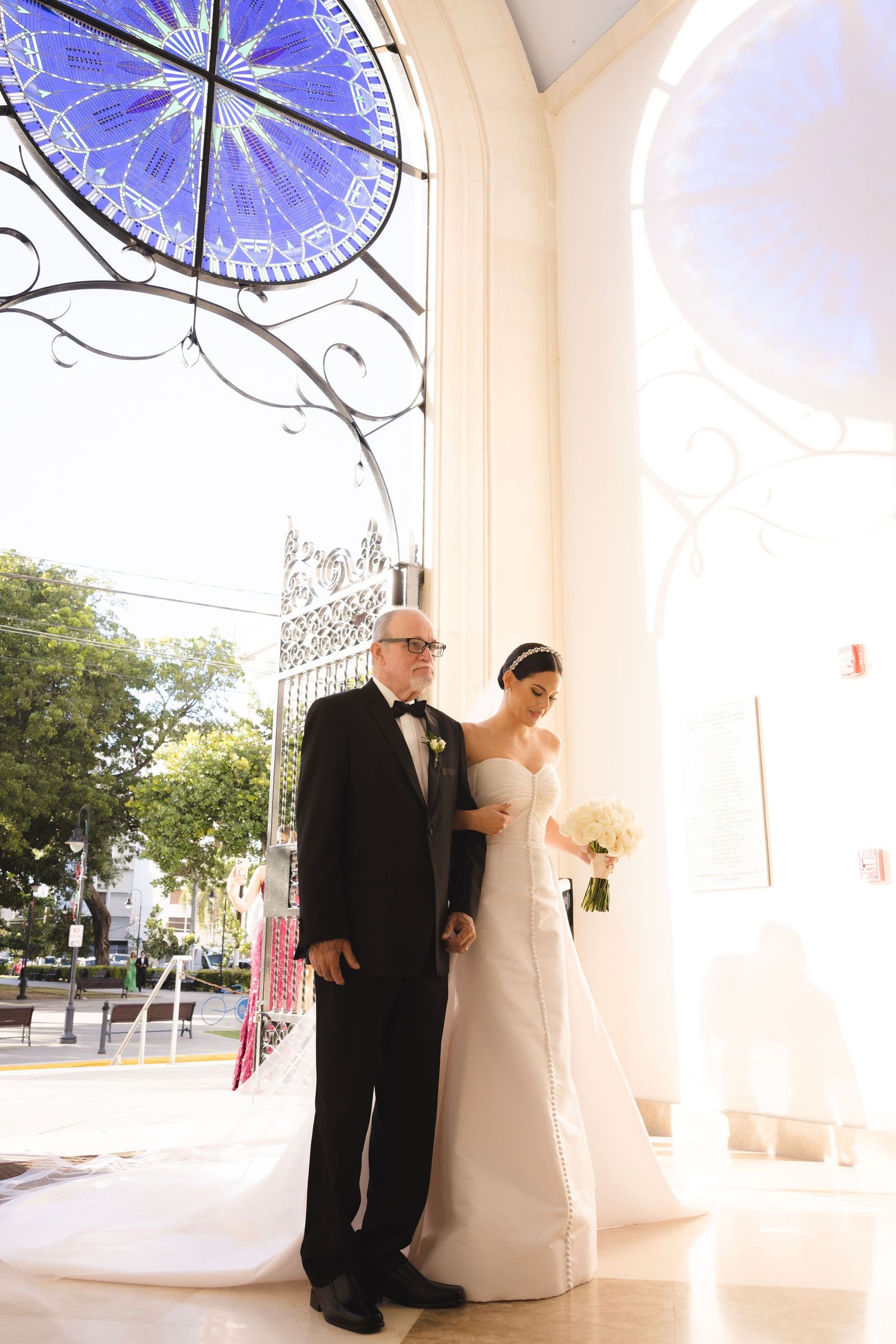 A series of five wedding photos showing a couple walking together under blue paper umbrella decorations at a venue entrance.
