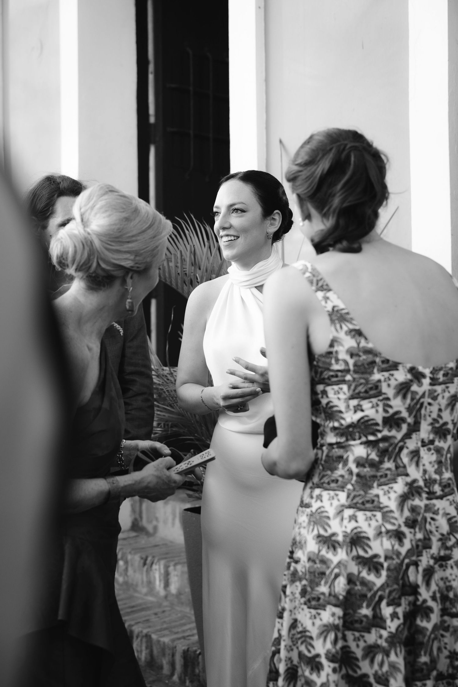 Wedding guests in formal attire gathering together in black and white photography.