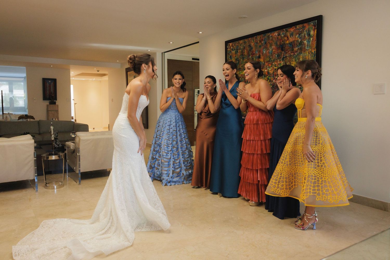 Wedding party in colorful dresses watches bride in white gown during special moment.